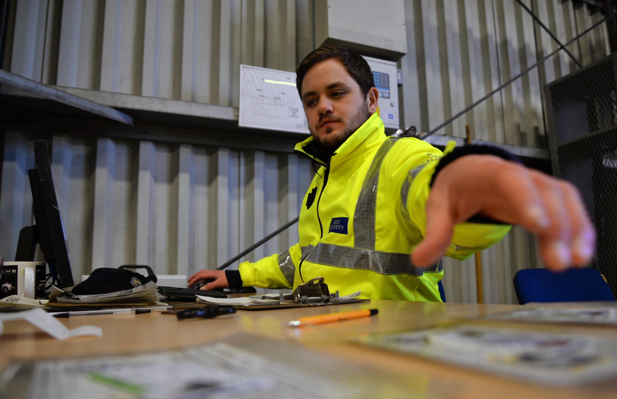 Sam Bannister, 100th Security Forces Squadron/Ministry of Defence civilian security officer, grabs a visitor’s photo ID and base pass Dec. 9, 2015, at the search barn on RAF Mildenhall, England. On an average day, officers inspect anywhere from 160 to 300 vehicles. Members inspect a range of cars including heavy-goods vehicles, contracting staff and visitors to the base. (U.S. Air Force photo by Senior Airman Christine Halan/Released)