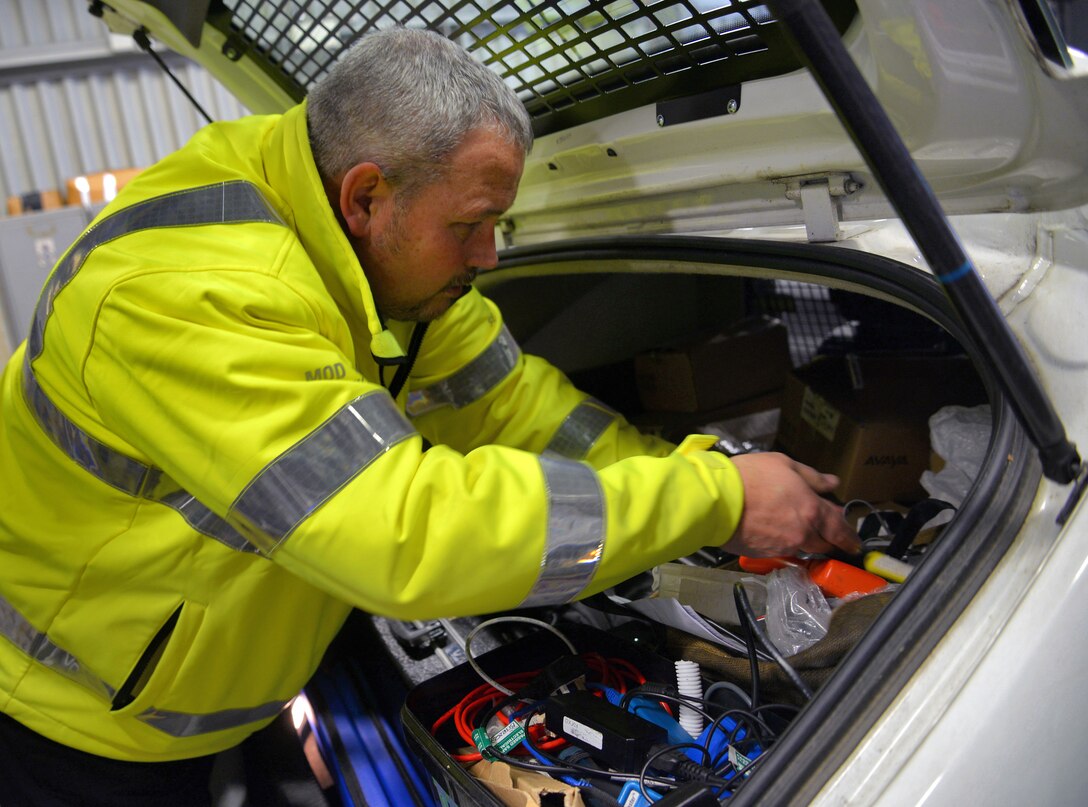 Mark Osborne, 100th Security Forces Squadron/Ministry of Defence civilian security officer, inspects a visitor’s car Dec. 9, 2015, in the search barn on RAF Mildenhall, England. Airmen from the 100th SFS and MGS officers search vehicles for explosives, unauthorized people, contraband and illegal weapons. (U.S. Air Force photo by Senior Airman Christine Halan/Released)
