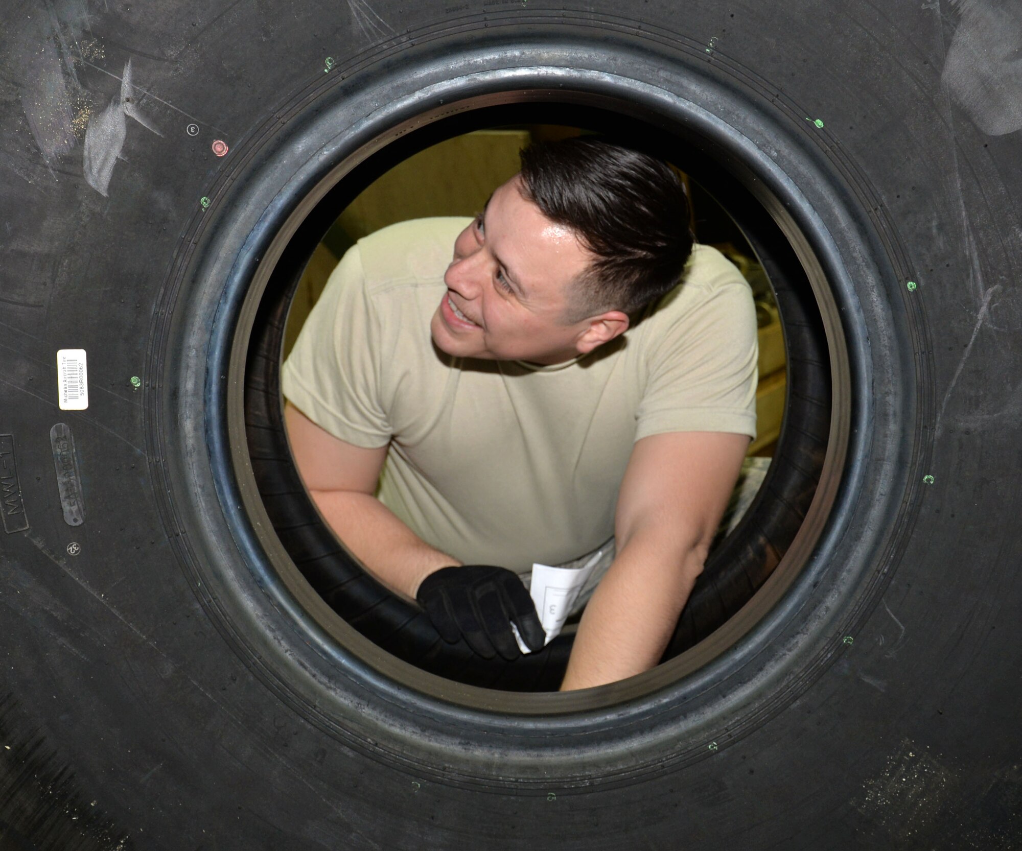 U.S. Air Force Senior Airman Marcus Anguiano, 100th Logistics Readiness Squadron Mobility Readiness Spares Packages technician, inspects the condition of a tire before it’s collected by the requesting unit Dec. 10, 2015, on RAF Mildenhall, England. The wheels and tires must be included in the support kit so they can be quickly changed when on a contingency deployment. (U.S. Air Force photo by Gina Randall/Released)