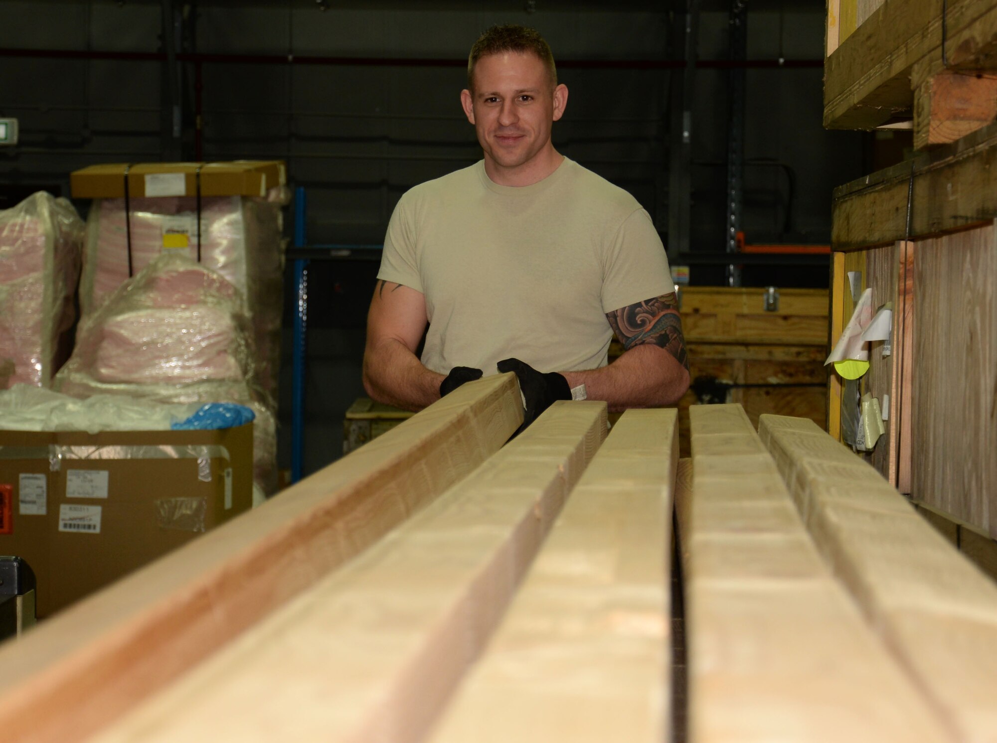 U.S. Air Force Staff Sgt. James Stay, 100th Logistics Readiness Squadron Mobility Readiness Spares Packages NCO in charge, takes a piece of wood that keeps pallet loads off the floor Dec. 10, 2015, on RAF Mildenhall, England. The wood allows forklifts to pick up and drop off pallets by making a gap between the pallet and the floor. (U.S. Air Force photo by Gina Randall/Released)