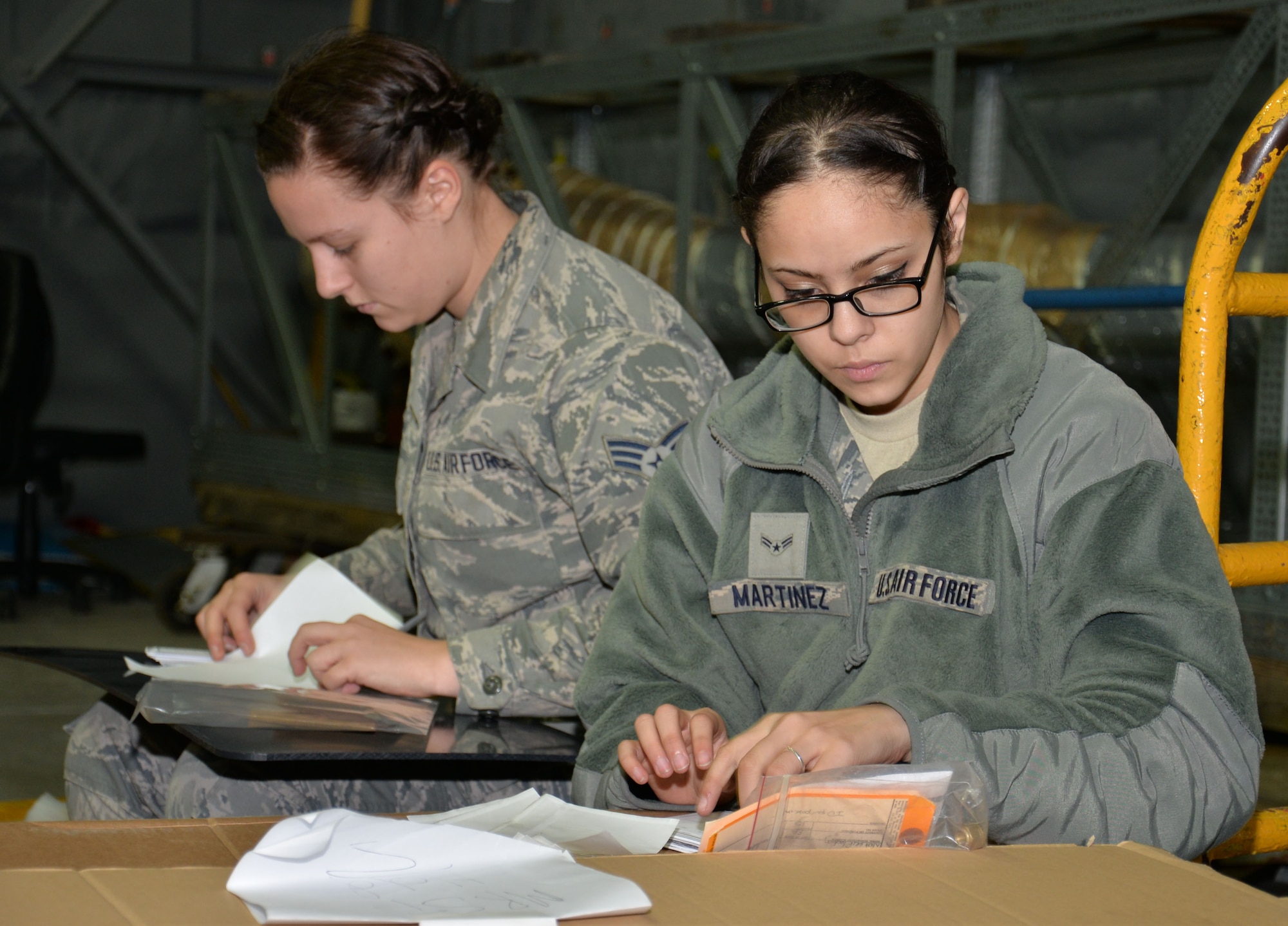 U.S. Air Force Senior Airman Andrea Smeal, left, and U.S. Air Force Airman 1st Class Alyssa Martinez, right, 100th Logistics Readiness Squadron Mobility Readiness Spares Packages technicians, in-check and verify CV-22 Osprey aircraft parts for a 352nd Special Operations Wing aircraft support kit Dec. 10, 2015, on RAF Mildenhall, England. The section receives, maintains, protects, inventories and issues 36,900 aircraft parts worth $120 million for five aircraft mobility readiness spares packages, supporting 15 KC-135 Stratotankers, eight MC-130J Commando II’s, and five CV-22 Ospreys. (U.S. Air Force photo by Gina Randall/Released)