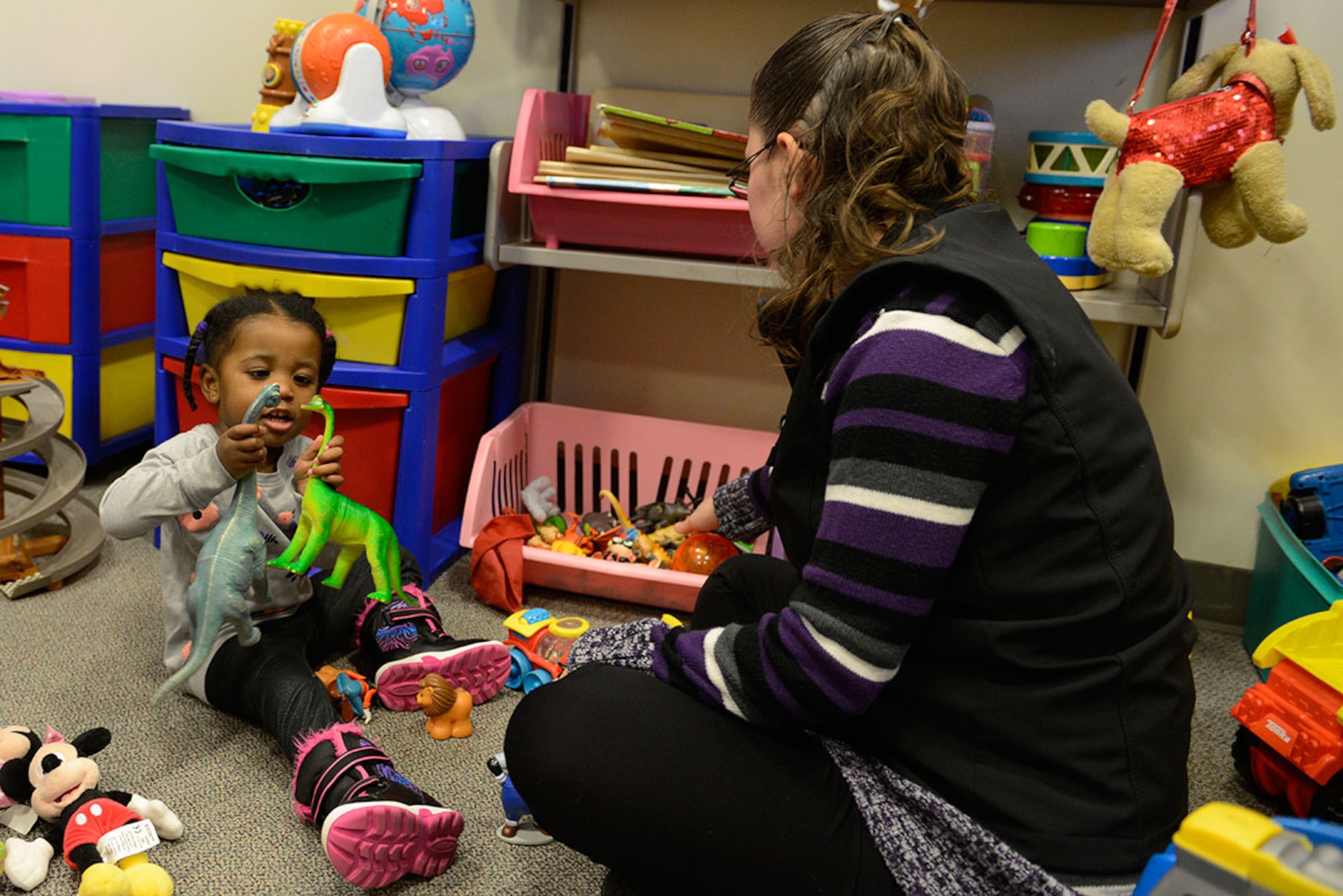 Tania Leslie, child watch specialist, plays with Olivia Powell, 2, at the Teddy’s Child Watch care center at Joint-Base Elmendorf-Richardson, Dec. 9. Teddy’s Child Watch is a free service that offers a safe place for children to be watched during appointments at the hospital. Olivia is the daughter of Damian Powell, with the 673d Surgical Operations Squadron, and Tanisha Powell. (U.S. Air Force photo/Airman Valerie Monroy)