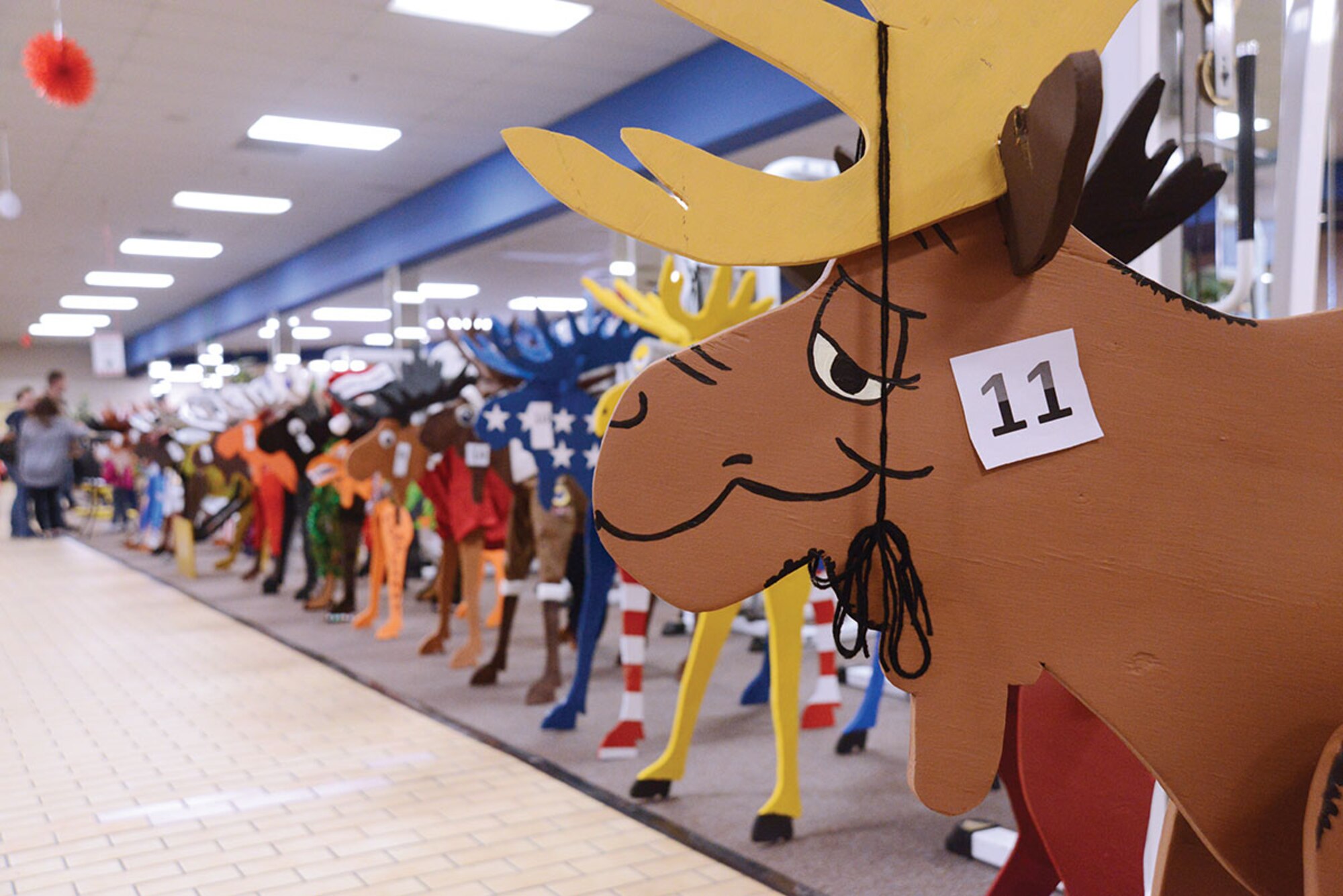 Wooden moose line up for judging during Breakfast with Santa at the Arctic Oasis at Joint Base Elmendorf-Richardson, Alaska, Dec. 12, 2015. The first, second and third place winners earn a cash prize after the votes have been cast. (U.S. Air Force photo by Airman 1st Class Christopher R. Morales)