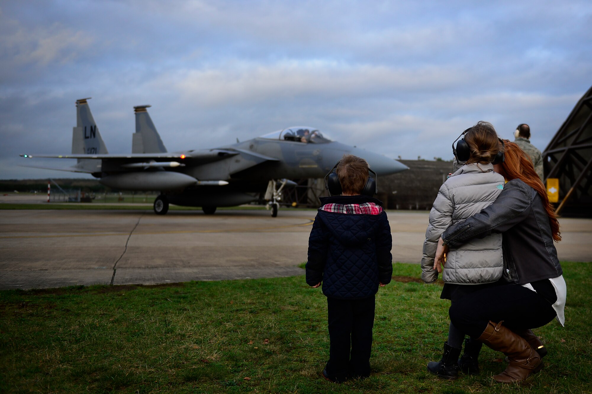 A family observes the arrival of a U.S. Air Force F-15C Eagle from the 493rd Fighter Squadron at Royal Air Force Lakenheath, England, Dec. 16, 2015. Six F-15Cs from the 48th Fighter Wing deployed to Incirlik to conduct training and operational missions supporting Turkish allies and their sovereign airspace. (U.S. Air Force photo/Airman 1st Class Erin R. Babis)