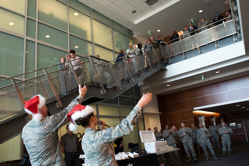 Senior Master Sgt. Ryan Carson and Tech. Sgt. Nalani Quintello, U.S. Air Force Band’s Max Impact vocalists, sing holiday carols in the lobby of the William A. Jones III building at Joint Base Andrews, Md., Dec. 16, 2015. Max Impact played a surprise performance for the military members and civilians that work in the Jones building to spread holiday cheer. (U.S. Air Force photo by Airman 1st Class Philip Bryant/Released)