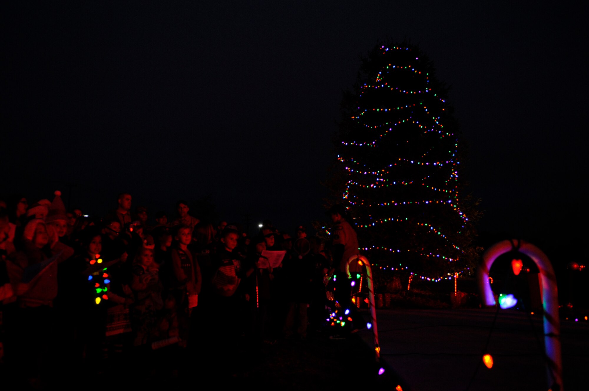 Local Boy and Girl Scouts sing Christmas carols during a Christmas tree lighting ceremony, Dec. 3, 2015, Vandenberg Air Force Base, Calif. Throughout the holiday season, the 30th Space Wing chapel will host a variety of religious programs and services. (U.S. Air Force photo by Senior Airman Shane Phipps/Released)