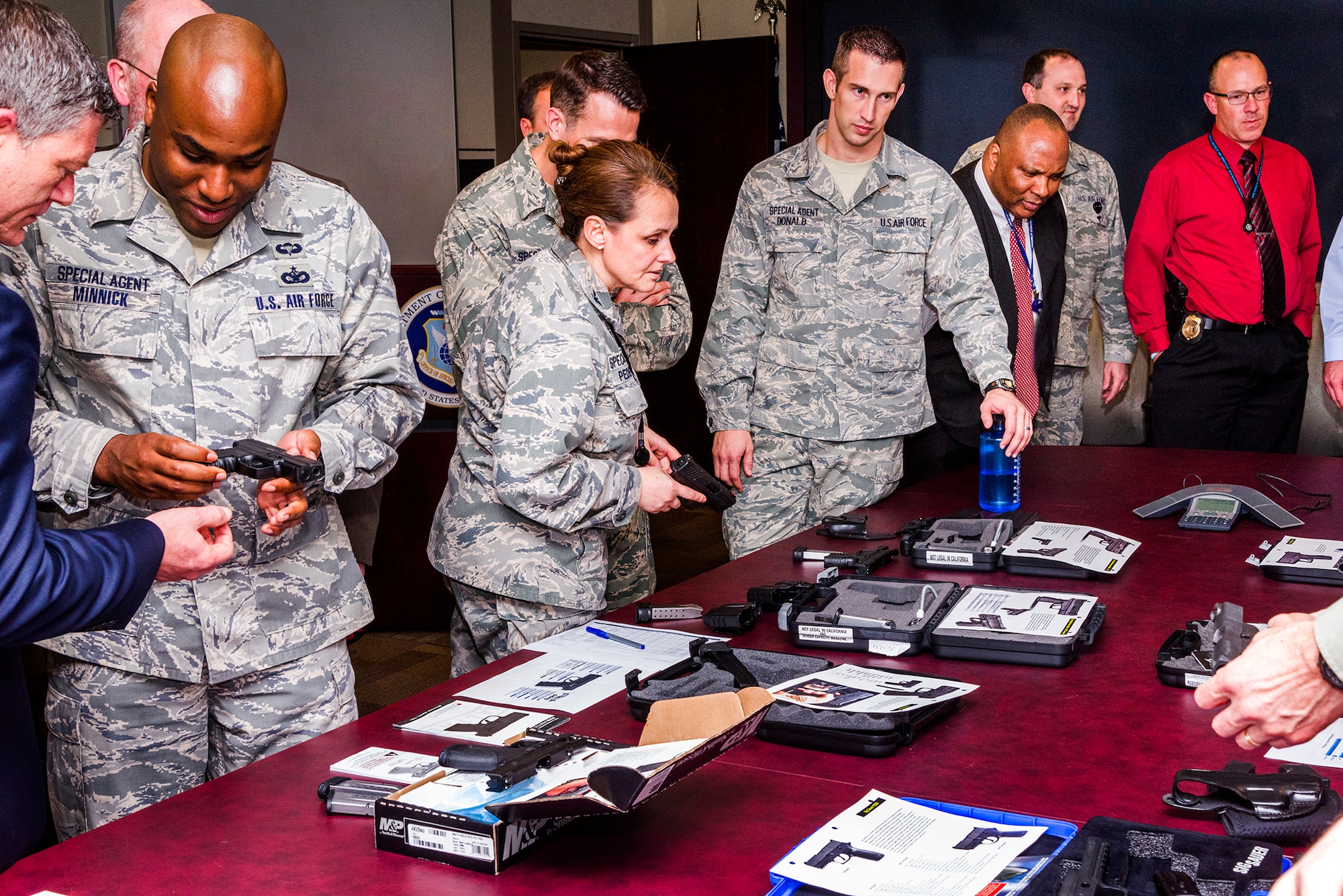 Air Force Office of Special Investigations members check out a display table of privately owned weapons Dec. 10 at OSI headquarters. The 10 guns showcased some of the options available to Special Agents who want to carry a POW in accordance with new OSI Weapons Program policy guidance. (U.S. Air Force photo by Michael Hastings)  
