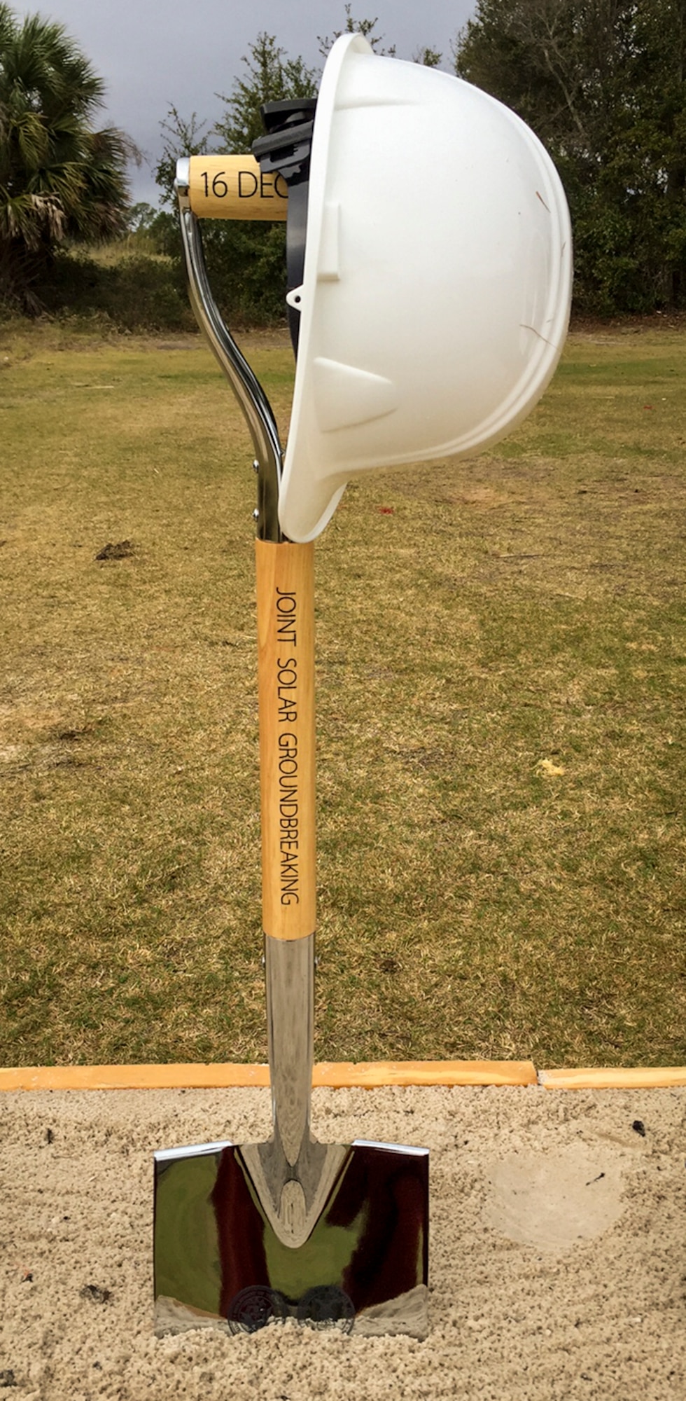 A commemorative shovel waits for the ceremonial ground breaking to begin Dec. 16 at NAS Pensacola.  The ceremony was held to mark the construction start of three large-scale solar electric generating facilities. The Solar Array facilities are a joint effort between the Air Force, Navy and Gulf Power to provide solar-powered electricity to 18,000 area homes over three counties.  (U.S. Air Force photo/Sara Francis)