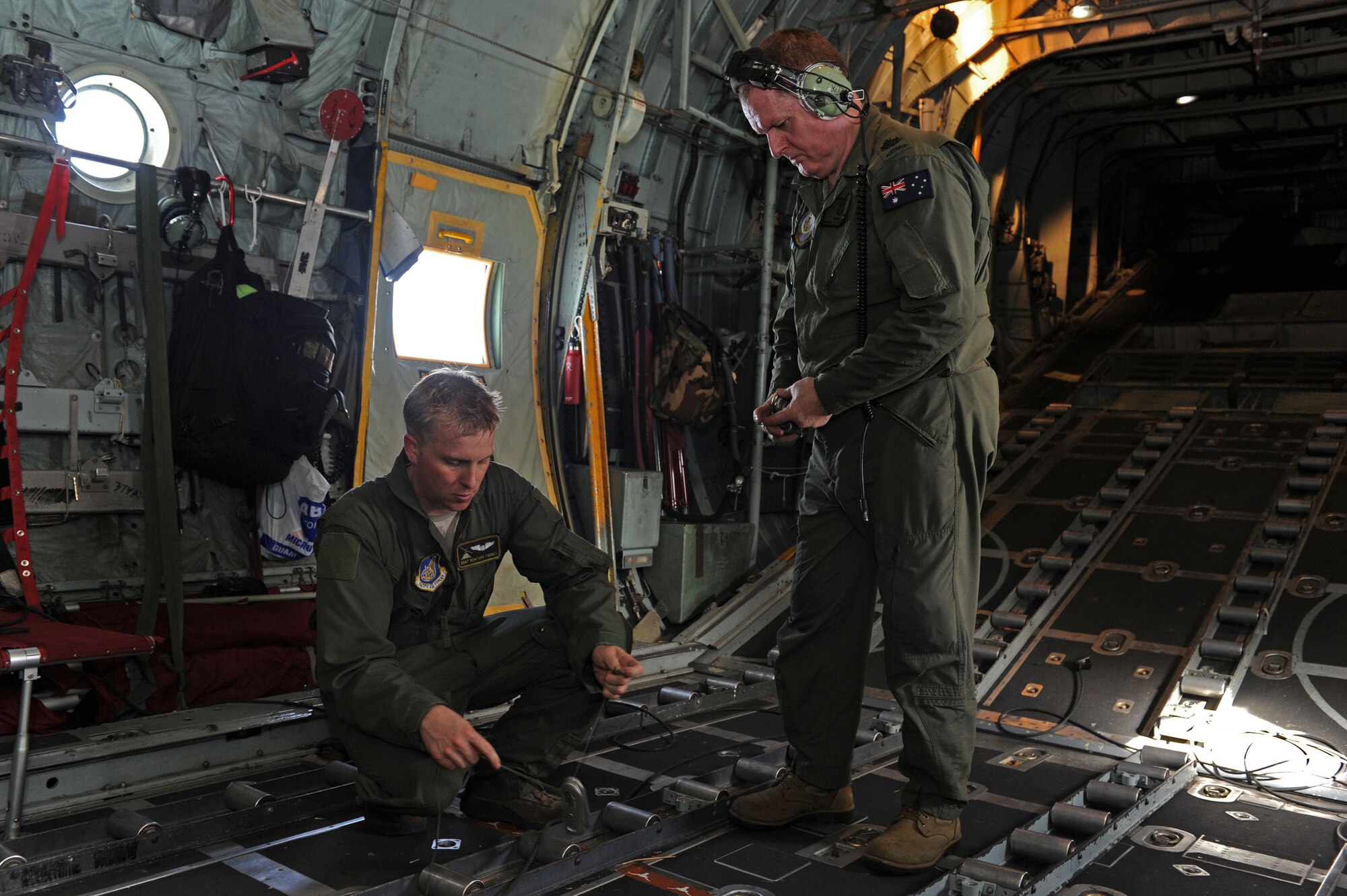 151211-N-ZB122-010 U.S. Air Force Staff Sgt. Ren Forbes, 36th Airlfist Squadron loadmaster (right), and Royal Australian Air Force Warrant Officer Rod Cairns (left) perform post-flight duties after successfully dropping multiple bundles to islands in the Federated States of Micronesia during Operation Christmas Drop, Dec. 11, 2015. Operation Christmas Drop is the Department of Defense’s longest running humanitarian airdrop mission where C-130 crews drop LCLA bundles filled with donated goods and supplies for 56 islands throughout the Commonwealth of the Northern Marianas, Federated States of Micronesia and Republic of Palau. This year marks the first ever trilateral execution that includes air support from the Japan Air Self-Defense force and Royal Australian Air Force C-130 crews. (U.S. Navy photo by Mass Communication Specialist 2nd Class Chelsy Alamina)
