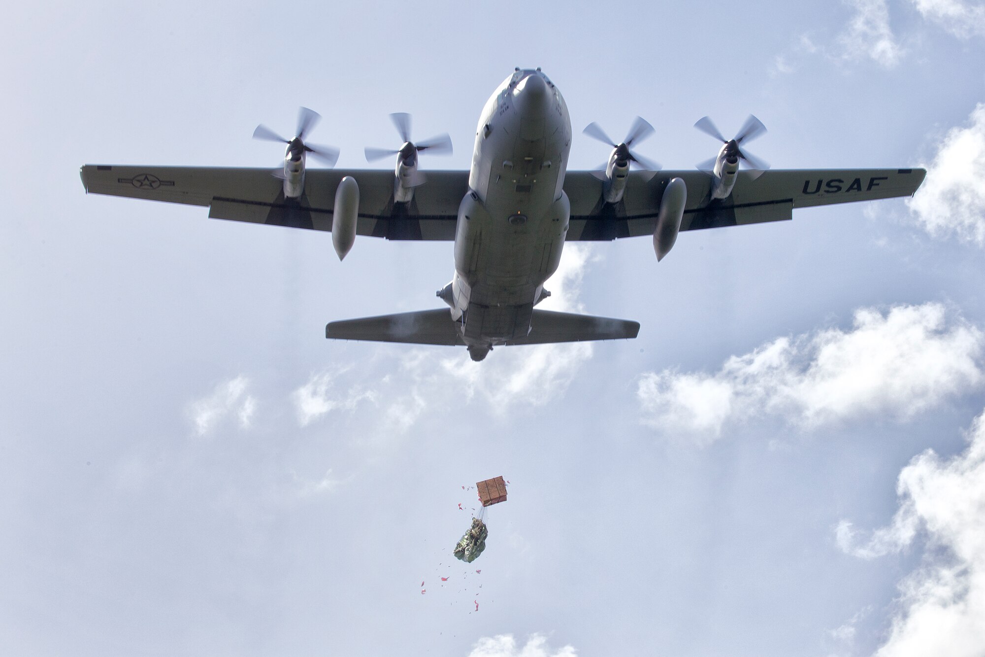 A C-130 Hercules assigned to the 36th Airlift Squadron drops a bundle filled with donated goods and supplies during Operation Christmas Drop 2015, at Fais island, Federated States of Micronesia, Dec. 8, 2015. Airmen delivered over 800 pounds of supplies to the island of Fais during the drop. This year marks the first trilateral Operation Christmas Drop where the U.S. Air Force, Japan Air Self-Defense Force and the Royal Australian Air Force work together to provide critical supplies to 56 Micronesian islands impacting 20,000 islanders. (U.S. Air Force photo by Osakabe Yasuo/Released)