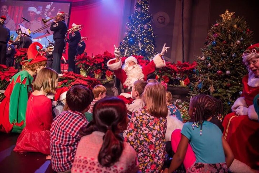 Santa sings with children who joined him and Mrs. Claus on stage at DAR Constitution Hall for The United States Air Force Band's Spirit of the Season holiday concert. (U.S. Air Force Photo by Senior Master Sgt Bob Kamholz/released)