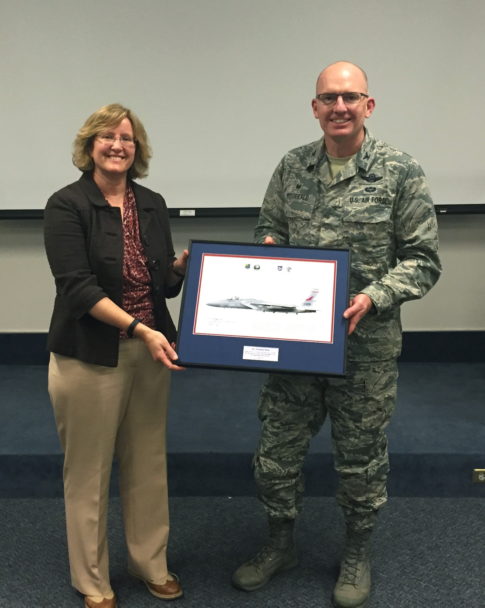 Col. Paul T. Fiztgerald, 142nd Fighter Wing commander, presents Dr. Rosemary King with a litho in appreciation for her two-day training on speech writing and delivery techniques held at Portland Air National Guard Base, Ore., Dec. 17, 2015.  King’s presentation skills training is the most recent contribution to the Wing’s ongoing mentorship program. (U.S. Air National Guard photo by 1st Lt. Chelsi Spence, 142nd Fighter Wing Public Affairs)