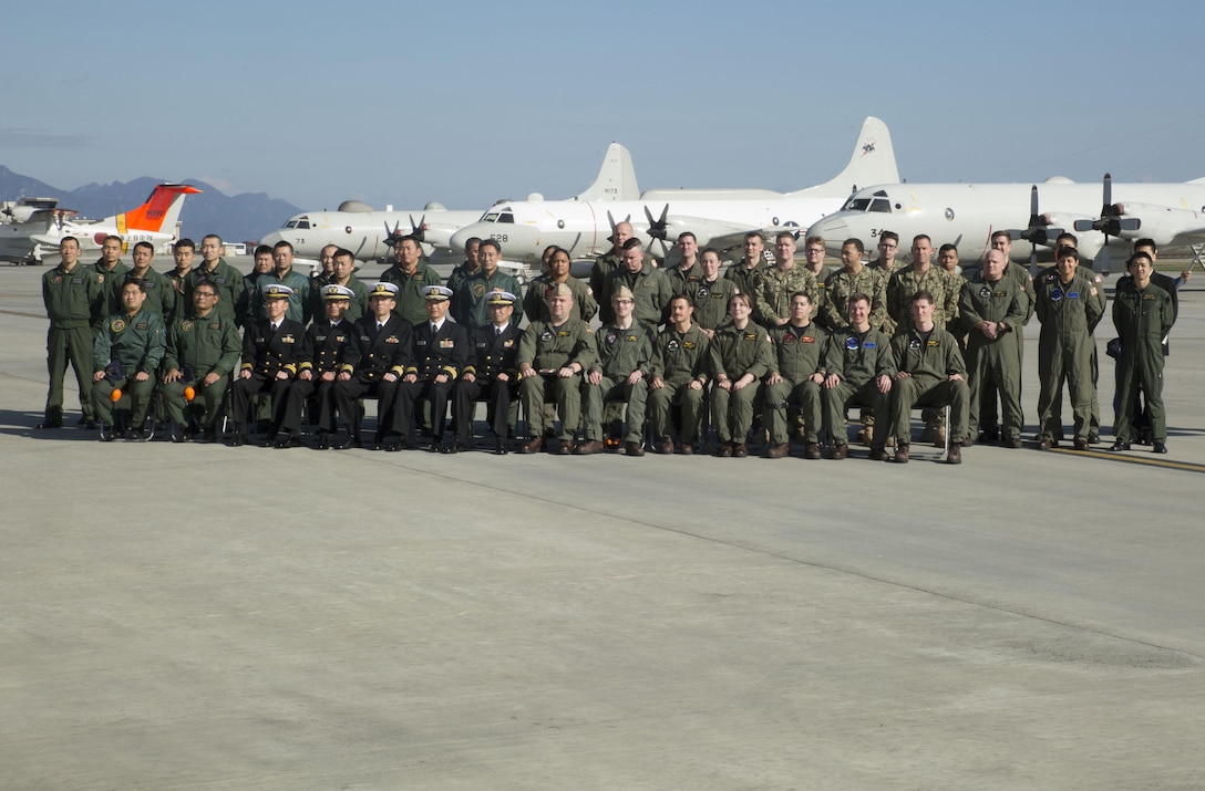 Members of the Japan Maritime Self-Defense Force Air Reconnaissance Squadron VQ-81 and Fleet Air Reconnaissance Squadron VQ-1 pose for a group picture at Marine Corps Air Station Iwakuni, Japan, Dec. 8, 2015. VQ-1 came to MCAS Iwakuni for an annual unit exchange between VQ-1 and VQ-81. The two units discussed their plans to increase their unit interoperability, strengthening the bond between the two units.