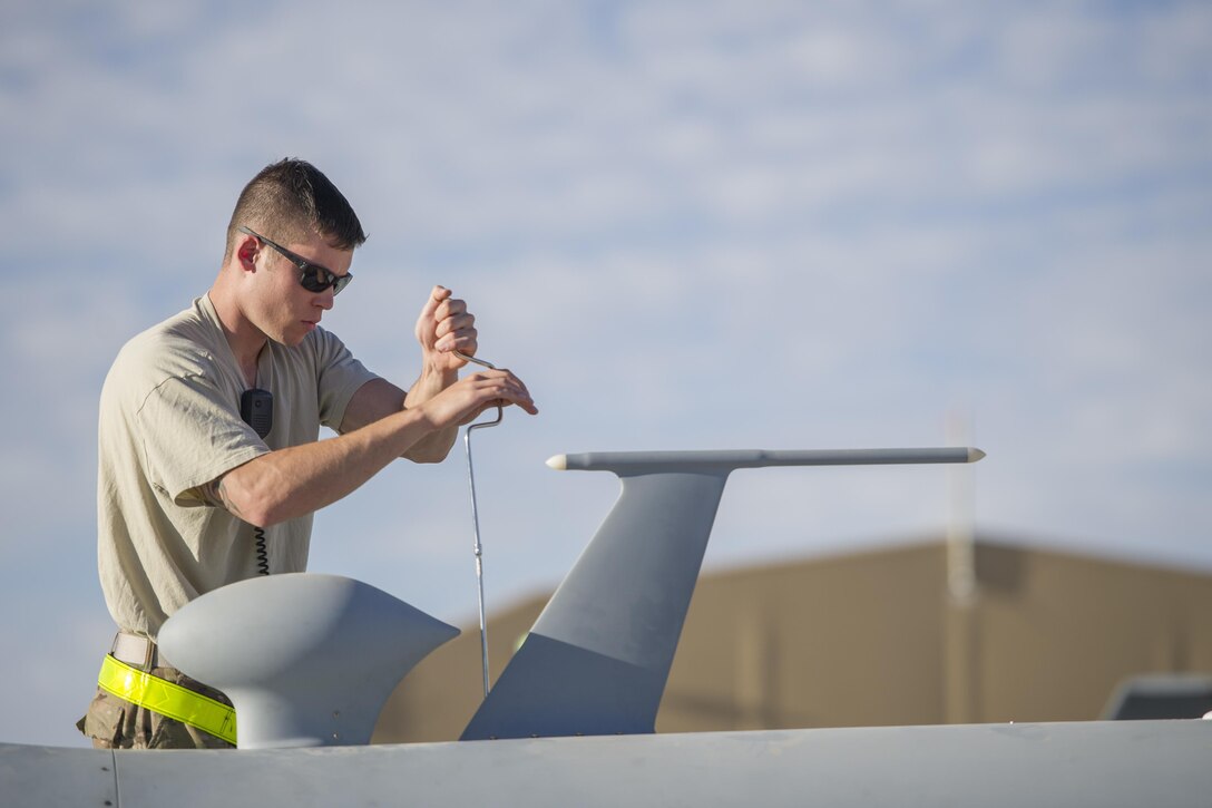 U.S. Air Force Senior Airman David secures a radio antenna on an MQ-9 Reaper before a sortie on Kandahar Airfield, Afghanistan, Dec. 5, 2015. David is an aircraft specialist assigned to the 62nd Expeditionary Reconnaissance Squadron. U.S. Air Force photo by Tech. Sgt. Robert Cloys