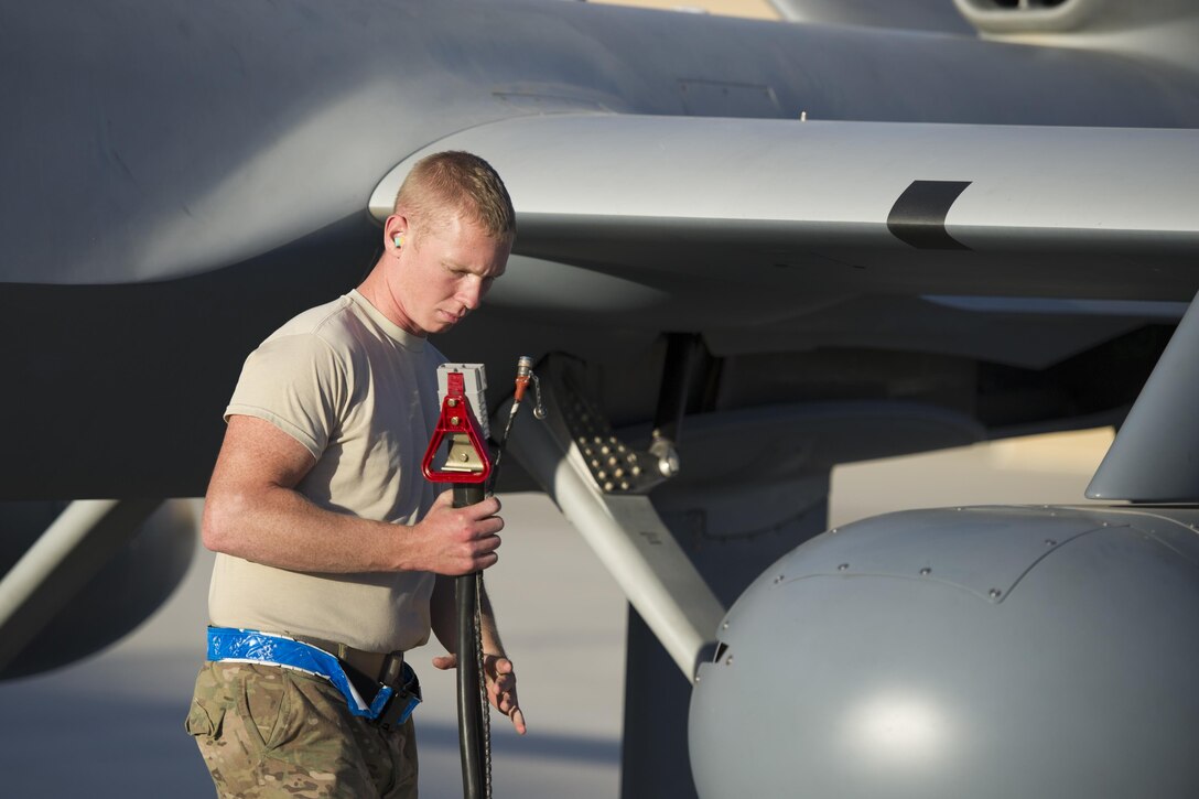 U.S. Air Force Airman 1st Class Landon removes a power cable from an MQ-9 Reaper before a sortie on Kandahar Airfield, Afghanistan, Dec. 5, 2015. Landon is an aircraft specialist assigned to the 62nd Expeditionary Reconnaissance Squadron. U.S. Air Force photo by Tech. Sgt. Robert Cloys
