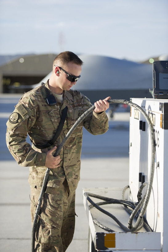 U.S. Air Force Airman 1st Class Tyler puts away a power cord after conducting preflight checks on an MQ-9 Reaper before a sortie on Kandahar Airfield, Afghanistan, Dec. 5, 2015. Tyler is a crew chief assigned to the 62nd Expeditionary Reconnaissance Squadron. U.S. Air Force photo by Tech. Sgt. Robert Cloys