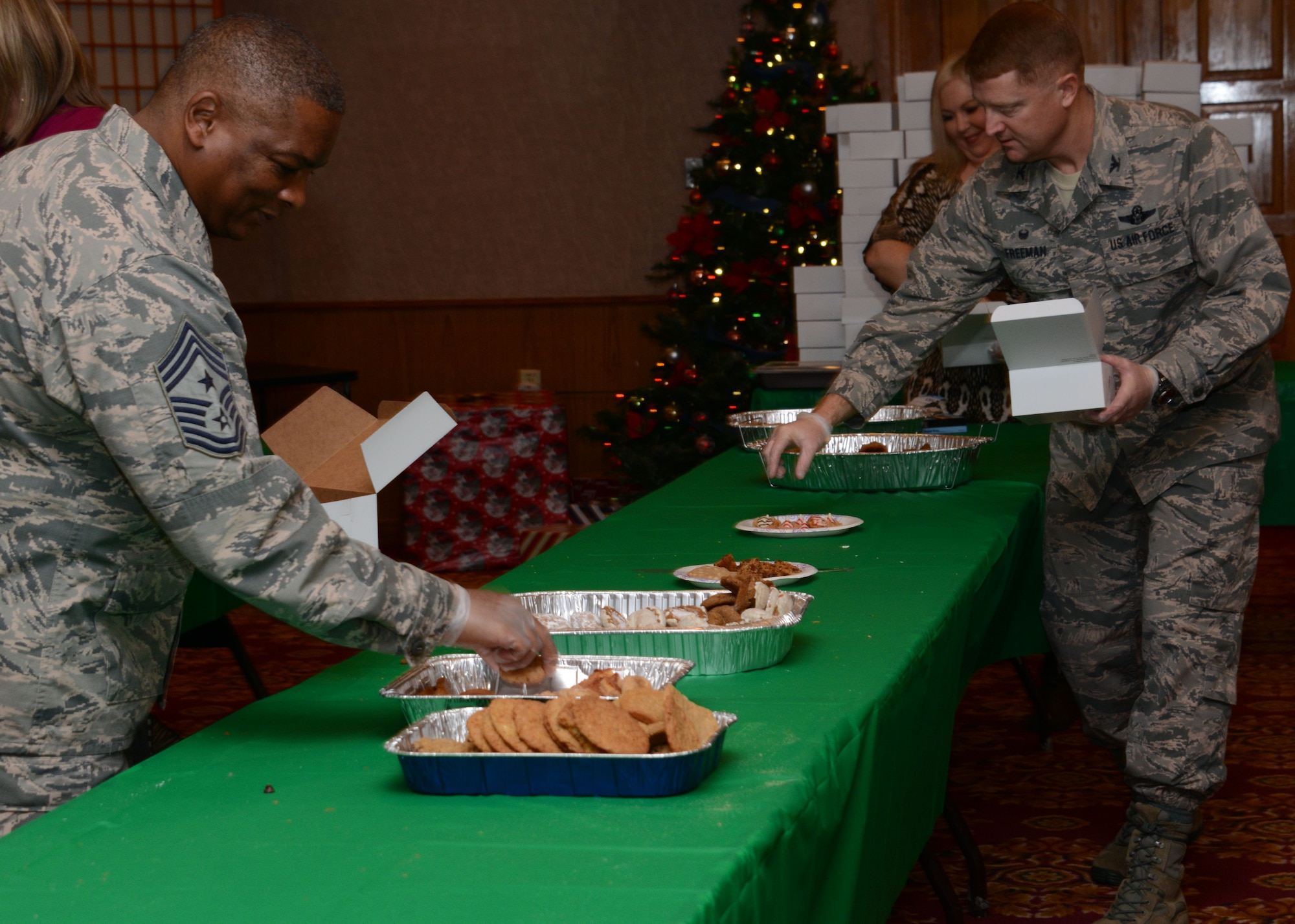 From left, Chief Master Sgt. Gilbert Edwards, 353rd Special Operations Group command chief, and Col. William Freeman, 353rd SOG commander, help pack cookie boxes during the Team Kadena 2015 Annual Cookie Drive Dec. 14, 2015 at Kadena.  This event hosted by the Kadena Spouses and Kadena First Sergeant association provided more than 30,000 cookies and treats to Kadena dorm residents.  (U.S. Air Force photo by Tech. Sgt. Kristine Dreyer)