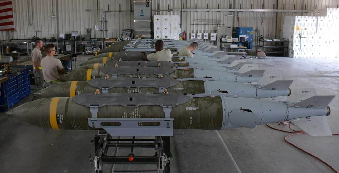 A dozen 2,000-pound joint direct attack munitions sit inside a warehouse at Al Udeid Air Base, Qatar Dec. 17. The bombs were built by hand by airmen from the 379th Expeditionary Maintenance Squadron’s Munitions Flight. The Munitions Flight has built nearly 4,000 bombs since July 2015. (U.S. Air Force photo by Tech. Sgt. James Hodgman/Released)
