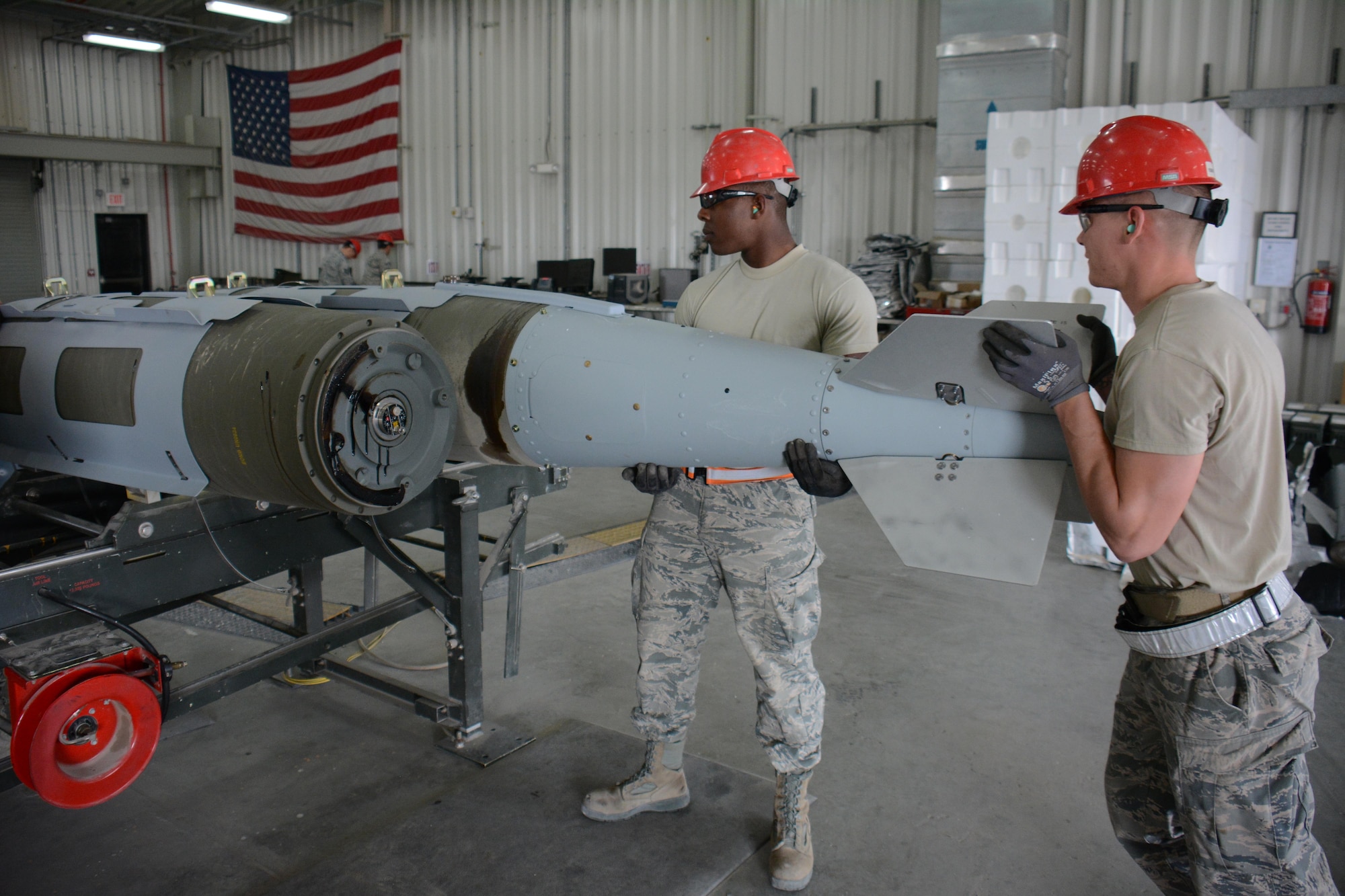 Senior Airman Christopher Haynesorth (left) and Staff Sgt. Daniel Eisenhart (right) both members of the 379th Expeditionary Maintenance Squadron Munitions Flight, install a tail kit on a 2,000-pound joint attack direct munition at Al Udeid Air Base, Qatar Dec. 17. Eisenhart, a native of Hanover, Pennsylvania, and Haynesworth, a native of Richmond, Virginia, are part of a record-setting munitions team that has built nearly 4,000 bombs since July 2015. (U.S. Air Force photo by Tech. Sgt. James Hodgman/Released)