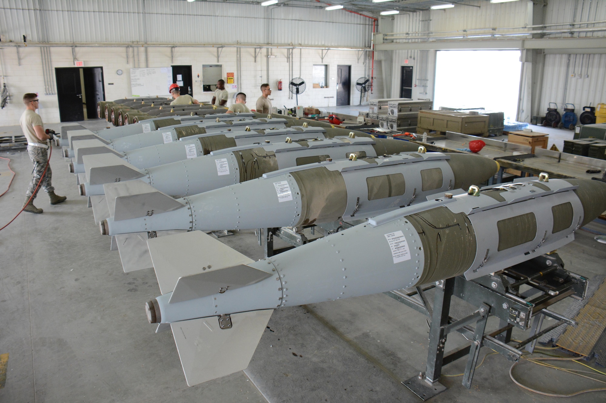 A dozen 2,000-pound joint direct attack munitions sit inside a warehouse at Al Udeid Air Base, Qatar Dec. 17. The bombs were built by hand by airmen from the 379th Expeditionary Maintenance Squadron’s Munitions Flight. The Munitions Flight has built nearly 4,000 bombs since July 2015. (U.S. Air Force photo by Tech. Sgt. James Hodgman/Released)