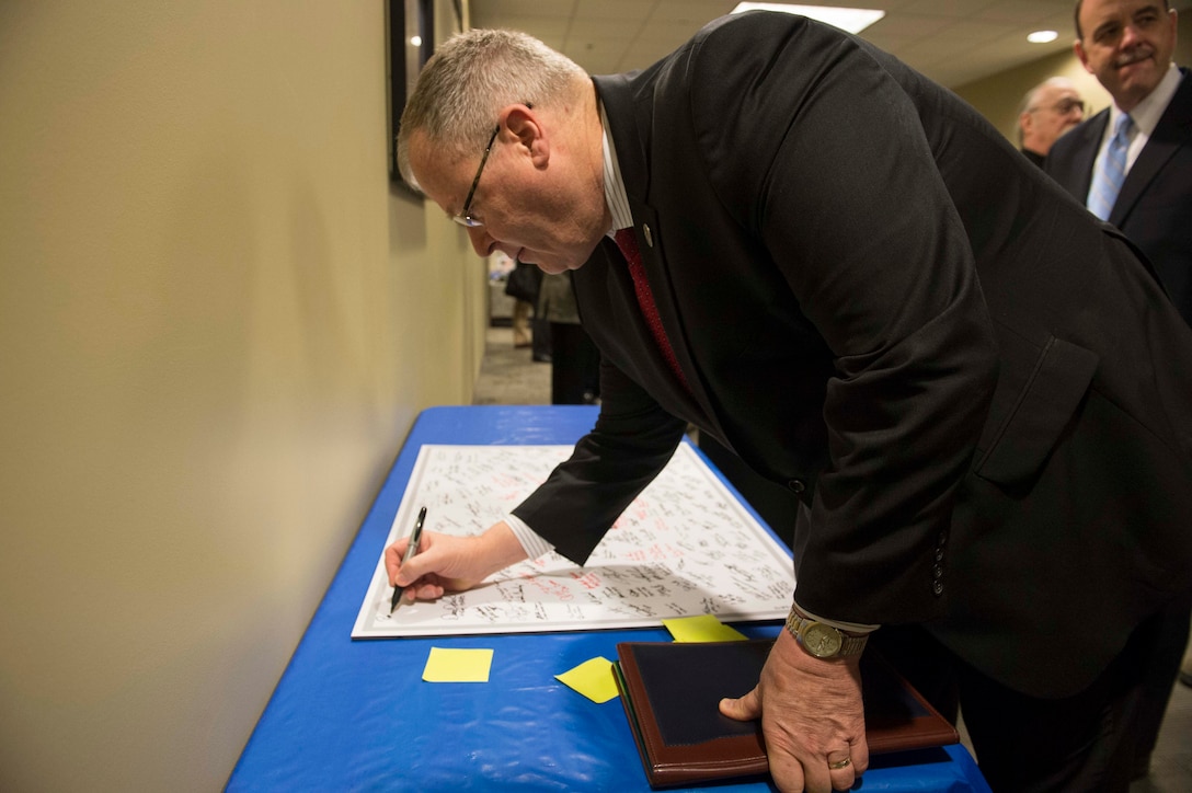 Deputy Defense Secretary Bob Work signs a guest board for the 2015 Schriever War Game on Schriever Air Force Base, Colo., Dec. 17, 2015. Work is in Colorado to meet with leaders and tour local commands. DoD photo by Navy Petty Officer 1st Class Tim D. Godbee