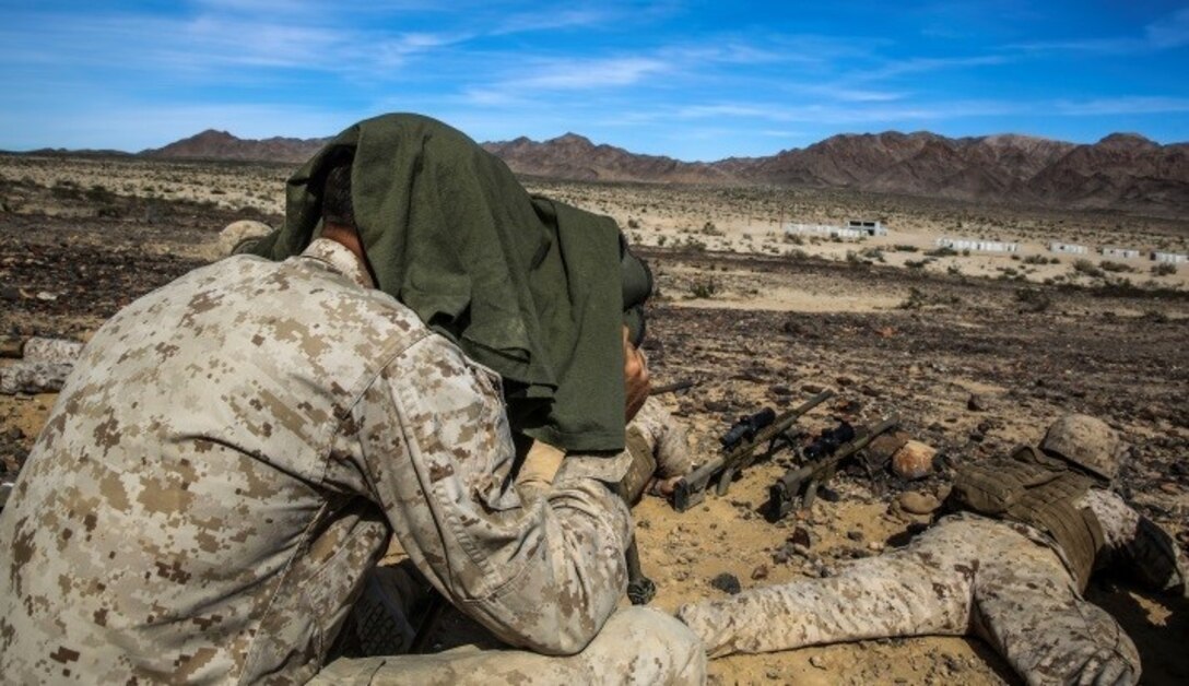 A Marine with 1st Battalion, 8th Marine Regiment observes snipers engaging targets during the sniper marksmanship assessment as part of Integrated Training Exercise 1-16 aboard Marine Air Ground Combat Center, Twentynine Palms, Calif., Oct. 24, 2015. During ITX, Marines demonstrate core infantry mission essential tasks while conducting offensive and defensive stability operations. (U.S. Marine Corps photo by Cpl. Immanuel M. Johnson/Released)