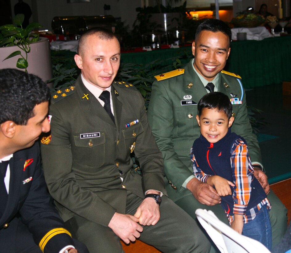Capt. Vasil Sisauri, from Georgia, Maj. Faris Wajdi, from Malaysia, and Muhammad, 4, also from Malaysia, at the Civilian Military Council evening social on Dec. 10. 