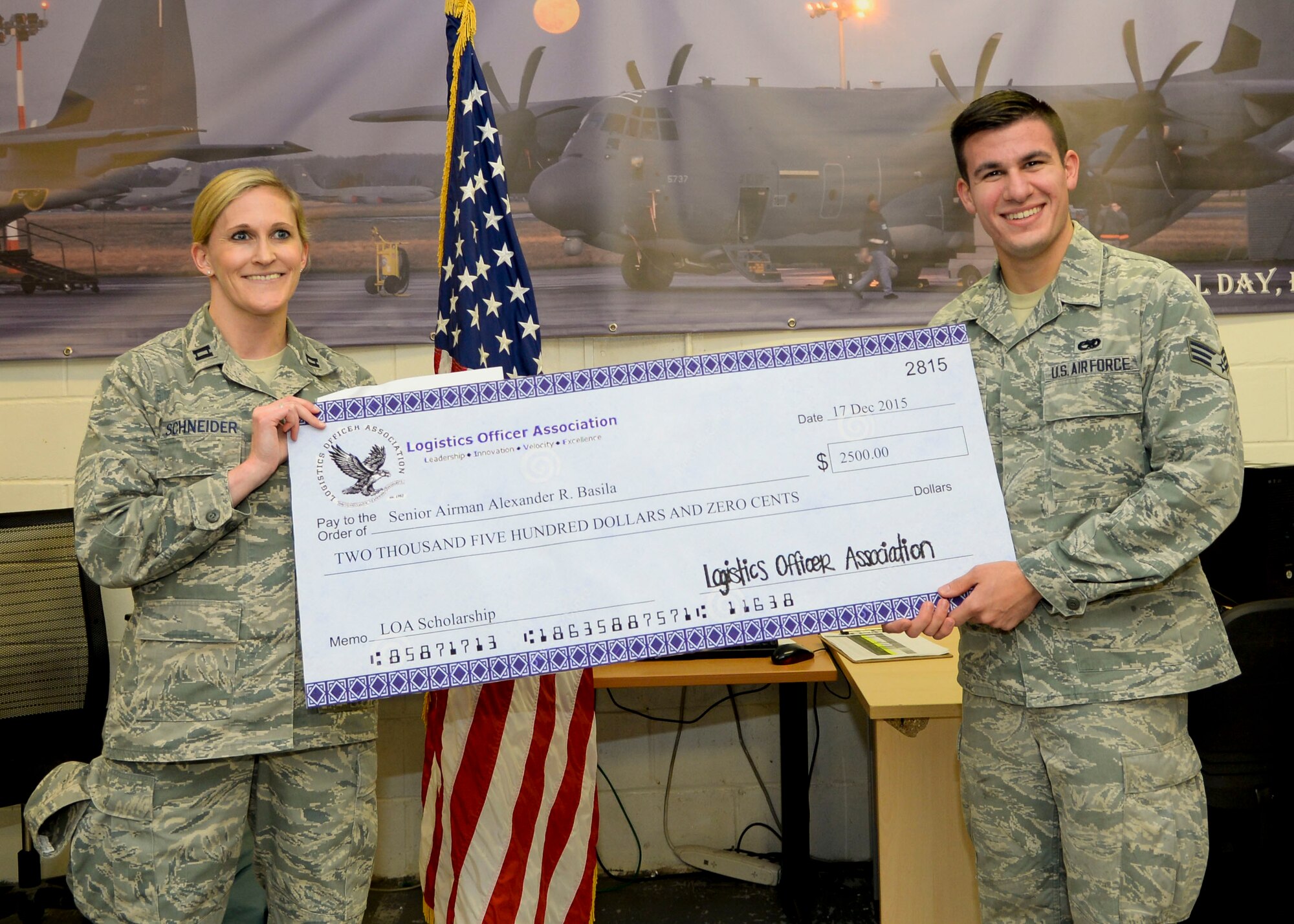 U.S. Air Force Senior Airman Alexanda Basila, 352nd Special Operations Aircraft Maintenance Squadron, receives a scholarship check Dec. 17, 2015, on RAF Mildenhall, England. Basila was awarded a Logistics Officer Association Scholarship of $2,500. He was nominated by his squadron commander to the Winston Churchill Chapter (RAF Mildenhall and RAF Lakenheath LOA Chapter), his nomination was forwarded his nomination to the LOA, and Basila was chosen as a scholarship recipient. (U.S. Air Force photo by Senior Airman Victoria H. Taylor/Released)