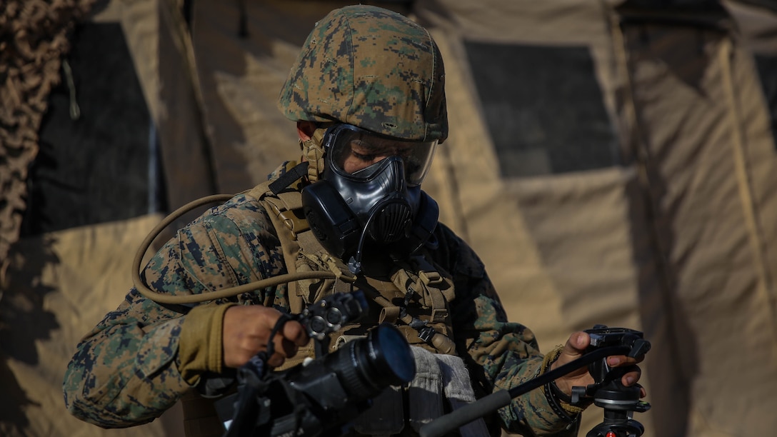 Lance Cpl. Carlos Lopez, a combat videographer with Headquarters Company, Headquarters Battalion, 1st Marine Division, prepares to capture video footage during a chemical, biological, radiological, nuclear drill designed to familiarize the Marines with immediate actions aboard Marine Corps Air Ground Combat Center Twentynine Palms, Calif., Dec. 13, 2015. The Marines and Sailors with 5th Marine Regiment conducted the gas drill as part of Steel Knight 2016, a division-led exercise which prepares Marines and Sailors with the 1st Marine Division and adjacent I Marine Expeditionary Force units with the skill sets necessary to operate as a fully capable Marine Air Ground Task Force. 