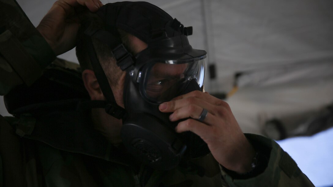 Navy Lieutenant Christopher Mullin, the regimental surgeon with 5th Marine Regiment, 1st Marine Division, dons his gas mask during a chemical, biological, radiological, nuclear drill designed to familiarize the Marines with immediate actions aboard Marine Corps Air Ground Combat Center Twentynine Palms, Calif., Dec. 13, 2015. The Marines and Sailors with 5th Marine Regiment conducted the gas drill as part of Steel Knight 2016, a division-led exercise which prepares Marines and Sailors with the 1st Marine Division and adjacent I Marine Expeditionary Force units with the skill sets necessary to operate as a fully capable Marine Air Ground Task Force.  