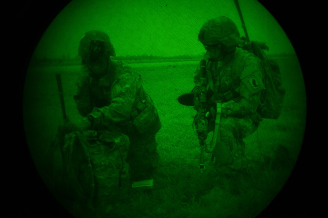 As seen through a night-vision device, U.S. Army paratroopers conduct a radio check during Exercise Rock Nemesis on Rivolto Air Base, Italy, Dec. 4, 2015. U.S. Army photo by Paolo Bovo