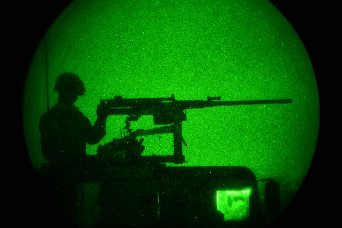 As seen through a night-vision device, a U.S. paratrooper mans a machine gun from the top of a vehicle while providing security during Exercise Rock Nemesis on Rivolto Air Base, Italy, Dec. 4, 2015. U.S. Army photo by Paolo Bovo