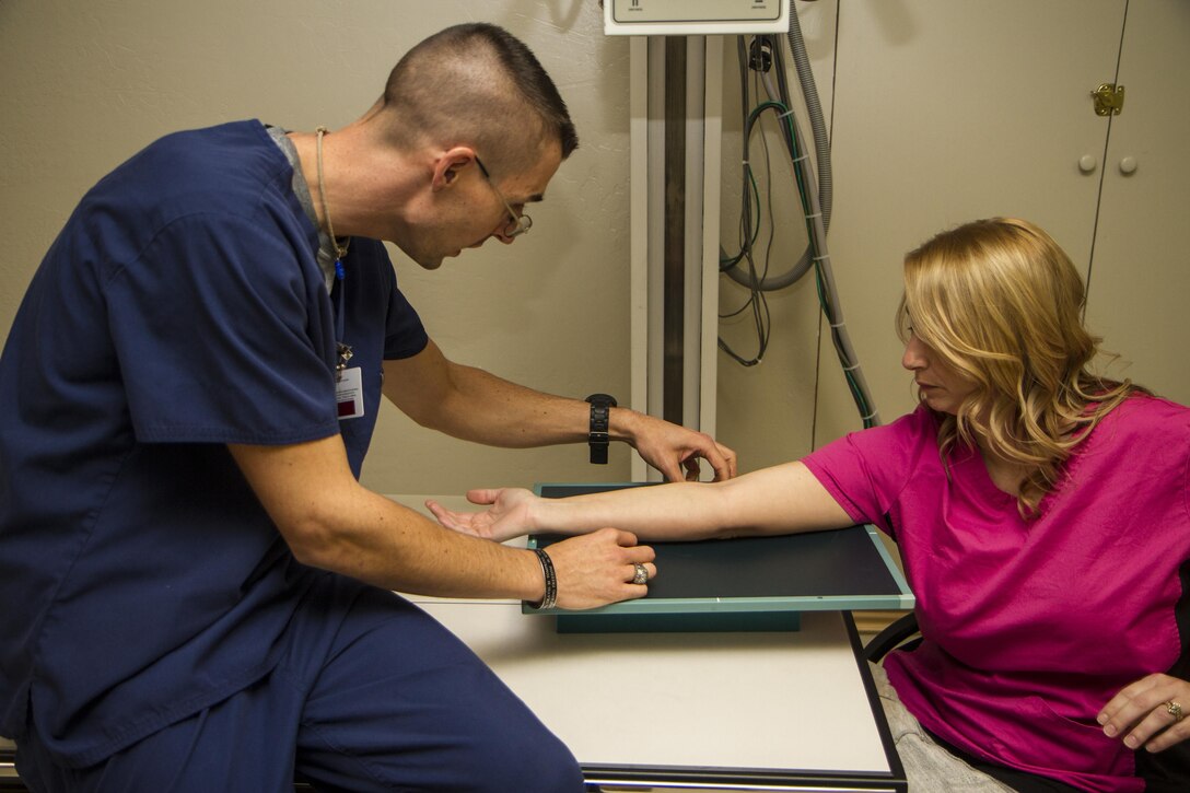 2015 Army Reserve Drill Sergeant of the Year, Staff Sgt. Mark Mercer of the 95th Training Division, prepares to X-ray the elbow of a patient at an orthopedic clinic in Edmond, Okla., Dec. 7, 2015. Mercer enlisted in 2002 with the Army Reserve as an X-ray technician and earned his civilian certification through his Army training. U.S. Army photo by Sgt. 1st Class Brian Hamilton