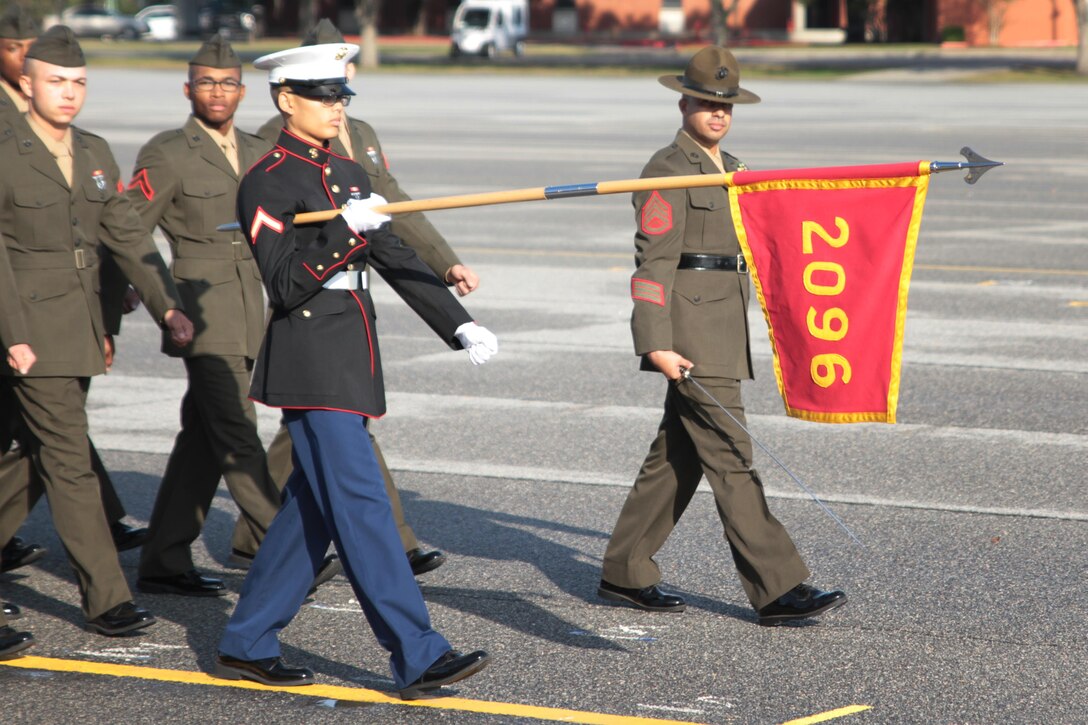 Pfc. Wanaboon B. Louangrath marches across the parade deck with his platoon's guidon, Dec. 18, 2015, at Marine Corps Depot Parris Island, S.C. Louangrath completed bootcamp as an Honor Graduated. Louangrath, a native of Spartanburg, S.C. was recruited by Sgt. Cory A. Brown at Recruiting Station Spartanburg. (Official Marine Corps photo by Cpl. Diamond N. Peden/Released)