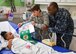 Maj. Polly Orcutt, 910th Airlift Wing public affairs officer, and Petty Officer 2nd Class Terrance Williams, a Sailor with the Navy Operational Support Center Youngstown, present a gift to a patient at Akron Children's Hospital's Boardman campus, Dec. 16. Service members from Youngstown Air Reserve Station visit children at the hospital annually. The Marine Corps Reserve center at YARS provides toys for distribution from their Toys for Tots program. (U.S. Air Force photo/Eric M. White). 