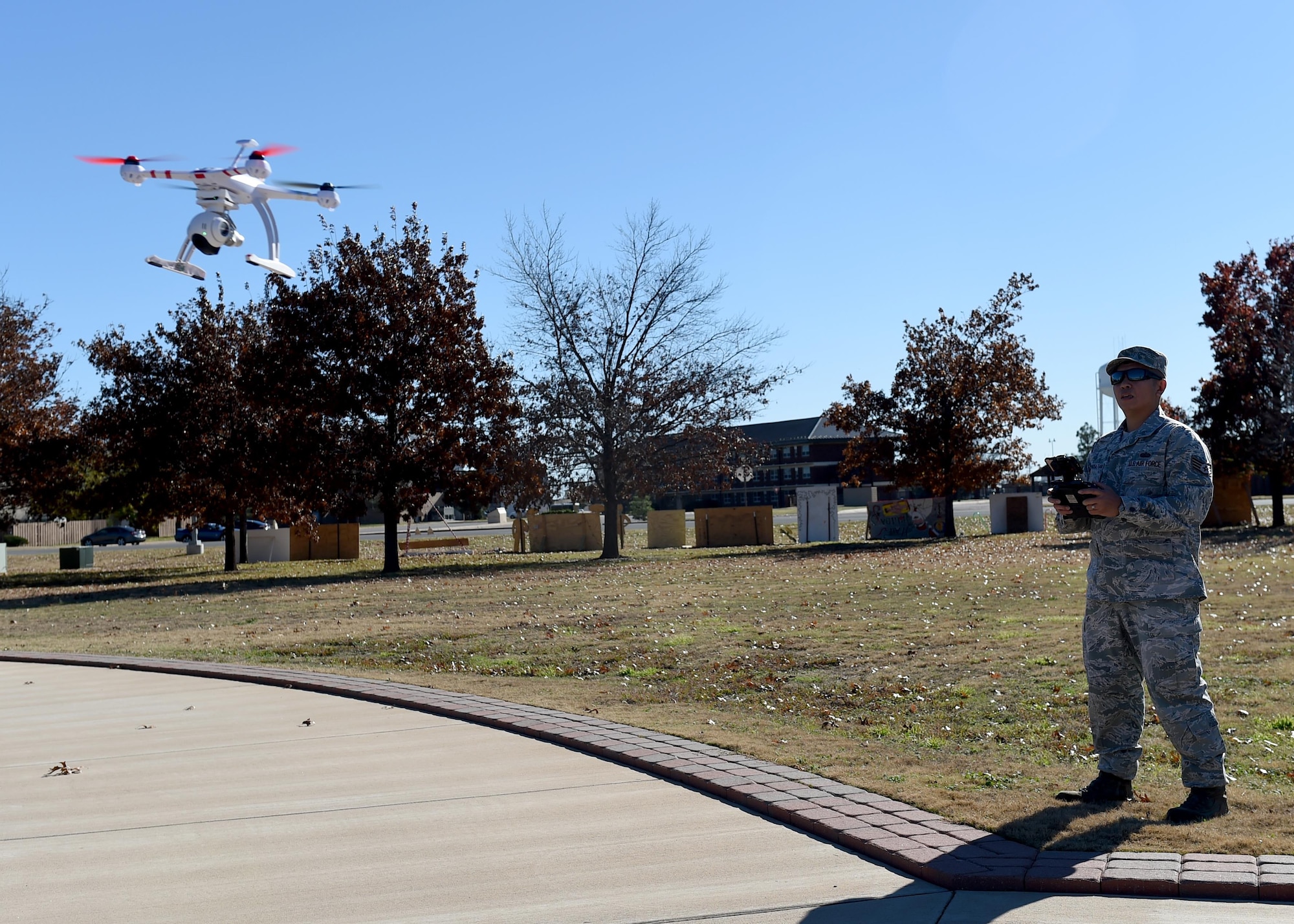 U.S. Air Force Staff Sgt. Anont Koonkongsatian, 97th Air Mobility Wing Safety Office safety technician and drone enthusiast, flies his drone to demonstrate how he uses it for official purposes at Wings of Freedom Park, Dec. 15, 2015. With the increase of drones’ popularity in the last few years, laws restricting the use of drones within 5 miles of an airbase have been made but some exceptions are made for official tasks such as checking roofs and showing cleared roadways on base. (U.S. Air Force photo by Airman 1st Class Kirby Turbak/Released)
