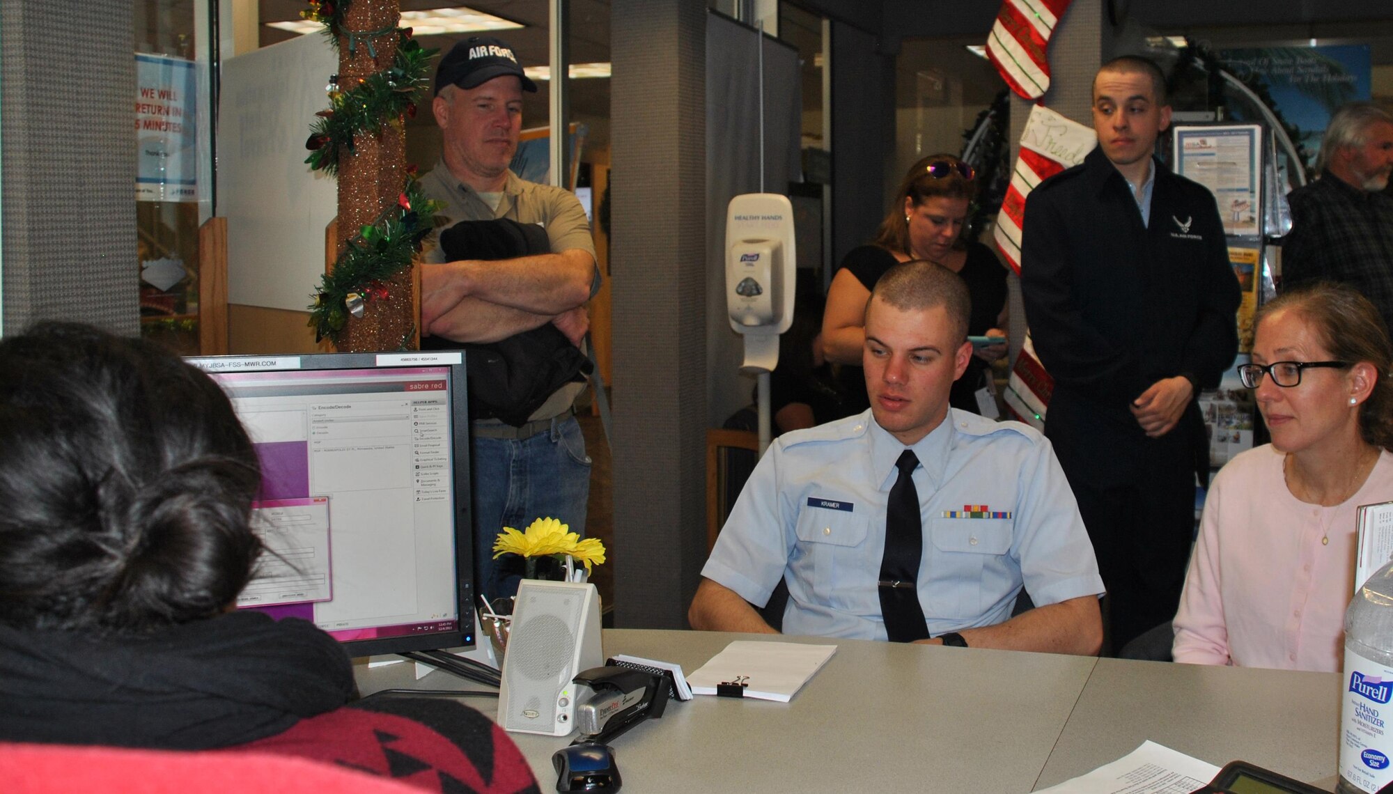 Airman Basic Timothy Kramer and his mother, Mary Kramer, work with Crystal Perez of the Air Force Leisure Travel Office at Joint Base San Antonio-Lackland, Texas, Dec. 4, to schedule holiday travel. This holiday season, agents at travel offices expect to help 6,500 Airmen get home for the holidays from four major training installations in the area: JBSA-Lackland; Sheppard Air Force Base, Texas; Goodfellow Air Force Base, Texas; and Keesler Air Force Base, Mississippi. (U.S. Air Force photo/Carole Chiles Fuller/Released)
