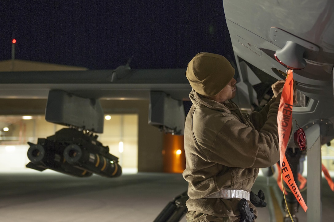 A U.S. Air Force master sergeant replaces a cap on an MQ-9 Reaper on Kandahar Airfield, Afghanistan, Dec. 6, 2015. The airman is a production superintendent assigned to the 62nd Expeditionary Reconnaissance Squadron. U.S. Air Force photo by Tech. Sgt. Robert Cloys