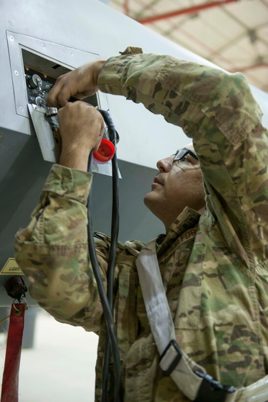 U.S. Air Force Senior Airman Curtis replaces a cap on an MQ-9 Reaper on Kandahar Airfield, Afghanistan, Dec. 6, 2015. Curtis is a weapons load crew member assigned to the 62nd Expeditionary Reconnaissance Squadron. U.S. Air Force photo by Tech. Sgt. Robert Cloys