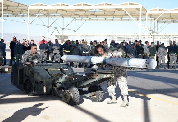 (left to right) Airman 1st Class Matthew Wolfe and Staff Sgt. Amy Zmakl, 61st Aircraft Maintenance Unit weapons load crew members, prepare to load an F-35 Lightning ll during the 4th quarter weapon's loading competition Dec. 18 at Luke Air Force Base, Ariz. This quarter featured the first time the F-35 was used in the competition against the F-16 Fighting Falcon at Luke. Three man crews from the 61st AMU, 309th AMU, 310th AMU, and the 425th AMU went head to head to earn this quarters win. (U.S. Air Force photo by Staff Sgt. Staci Miller)
