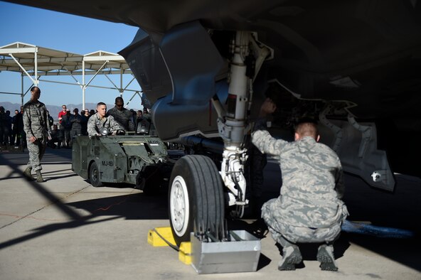 Weapons load crew members from the 61st Aircraft Maintenance Unit load an F-35A Lightning ll during a load crew competition Dec. 18, 2015, at Luke Air Force Base, Ariz. For the first time, the F-35 was used in the competition against the F-16 Fighting Falcon at Luke AFB. (U.S. Air Force photo/Staff Sgt. Staci Miller)