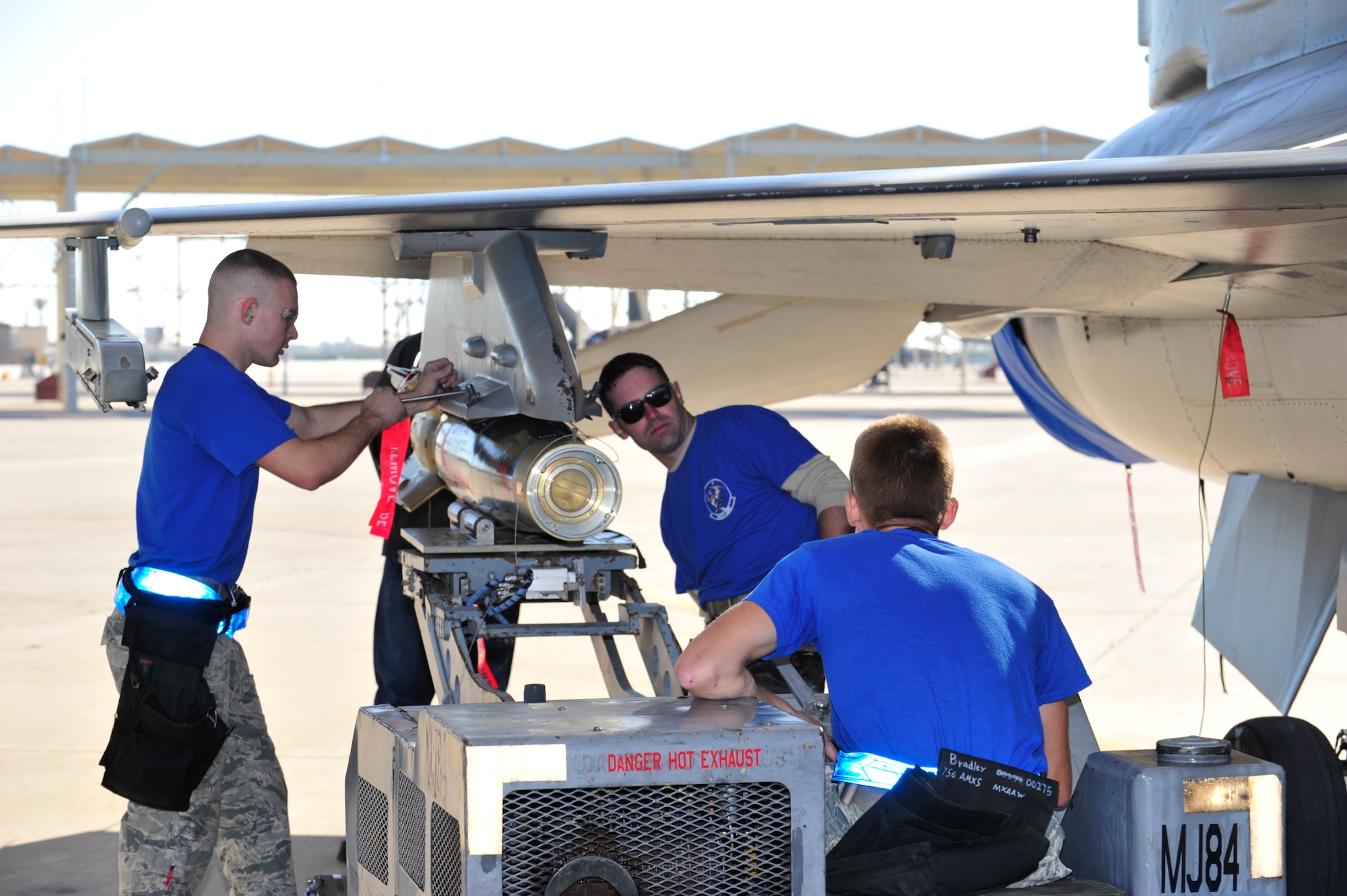 309th Aircraft Maintenance Unit weapons load crew members, prepare to load an F-16 Fighting Falcon during the 4th quarter weapon's loading competition Dec. 18 at Luke Air Force Base, Ariz. This quarter featured the first time the F-35 Lightning ll was used in the competition against the F-16 at Luke. Three man crews from the 61st AMU, 309th AMU, 310th AMU, and the 425th AMU went head to head to earn this quarters win. (U.S. Air Force photo by Senior Airman Grace Lee)