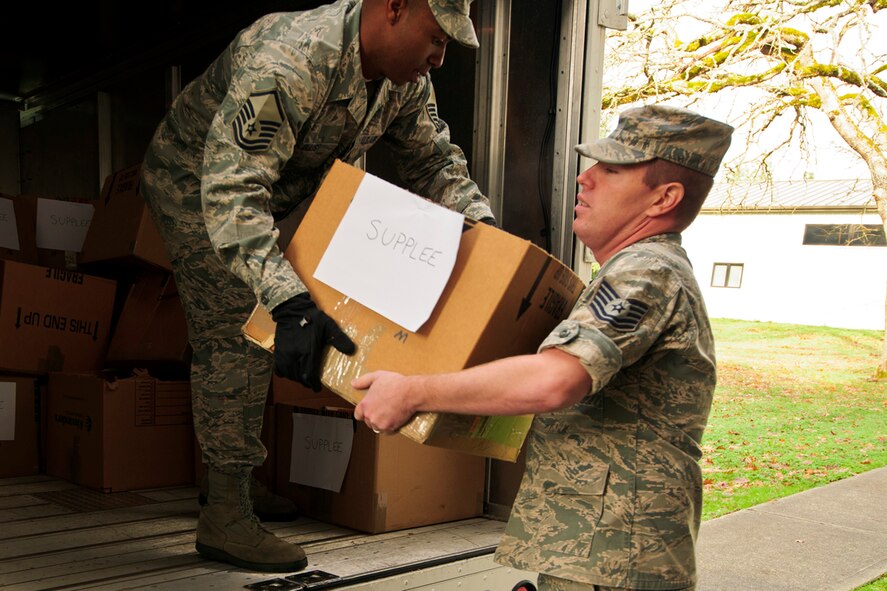 Reservists with the 446th Airlift Wing here, unload food boxes at the wing annex, Dec. 15, 2015. Food baskets for the December holidays are donated by the Central Pierce County Fire Department, Tacoma, Washington. The department donated 50 of its 450 dinner boxes to the wing Care and Share program, run by the 446th Force Support Squadron, Airman & Family Readiness Center here. Food drives are the cornerstone of Care and Share because they support Reserve families, who endure financial stress during the holiday season, said Mr. Carl Supplee, A&FRC director.