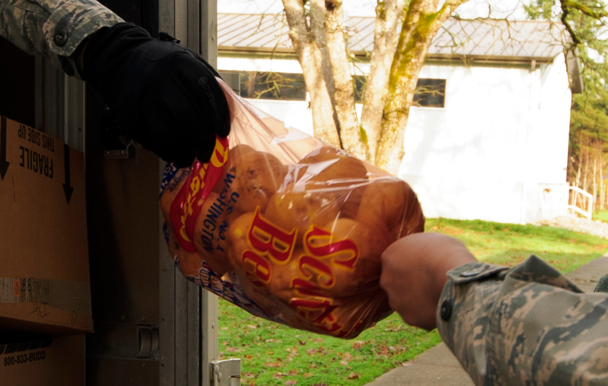 A bag of potatoes reaches the halfway point of its journey from the Central Pierce Fire & Rescue Department, Tacoma, Washington, to the 446th Airlift Wing Annex here, enroute to a deserving Reserve family's home, Dec. 15, 2015. The potatoes, along with other various perishable food items were donated to the wing as part of the Central Pierce Food Basket Program, where department members create dinner boxes from donated goods, so families in need can have a holiday dinner. The department built 450 food baskets, 50 of which were given to the 446th AW Care and Share Program, for Reserve families in troubled times during the holiday season. This is the 12th consecutive year the wing has partnered with the department.