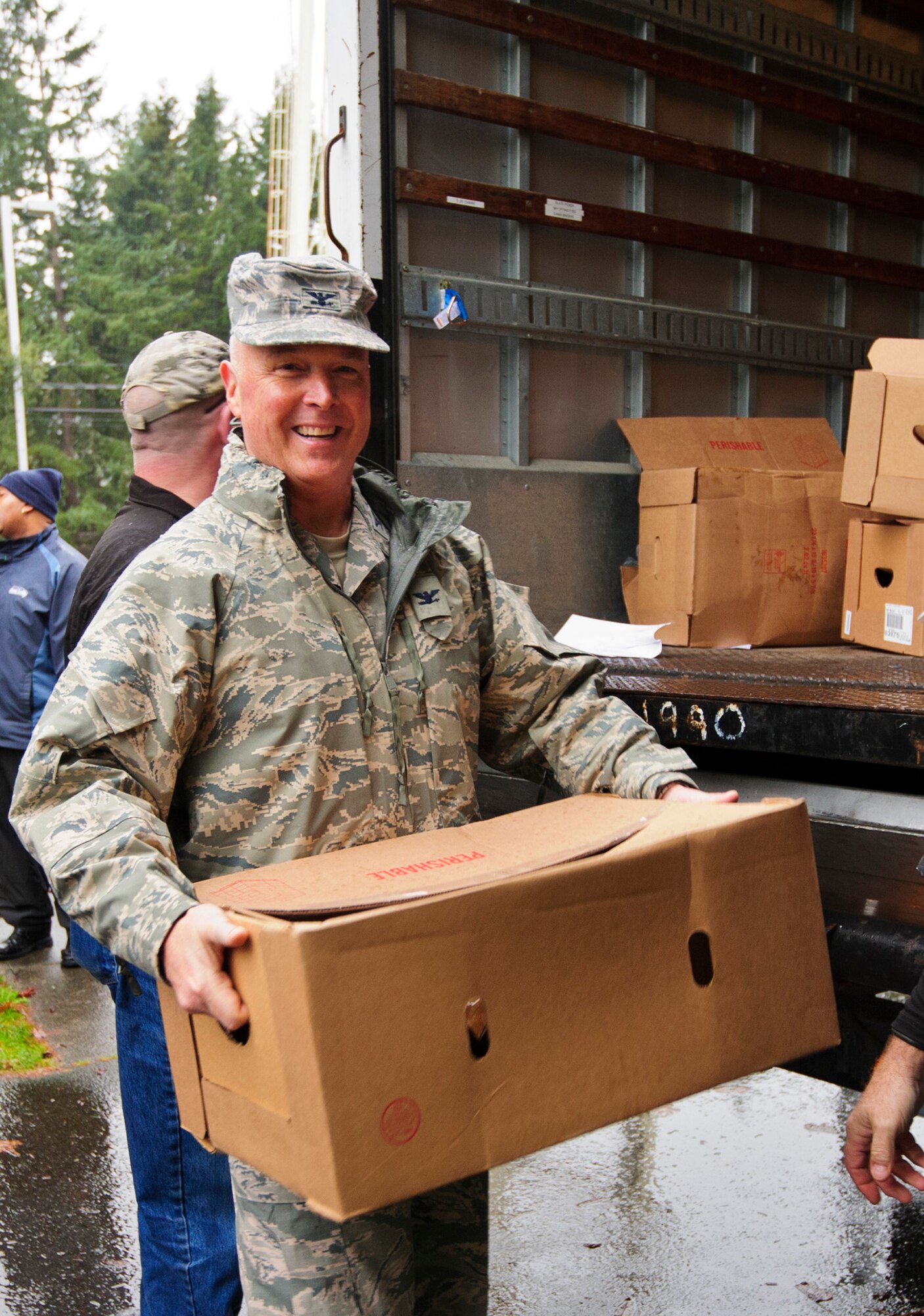 Col. Scott McLaughlin, 446th Airlift Wing commander, chips in with unloading boxes of ham at the 446th AW Annex here, Dec. 17, 2015 as part of Operation Ham Grenade, which local community leaders, organizations, and individuals donate hams to Airmen for their holiday dinners. A total of 44 hams were donated to the 446th AW Care and Share program, which supports Reserve families, who endure financial stress during the holiday season.
