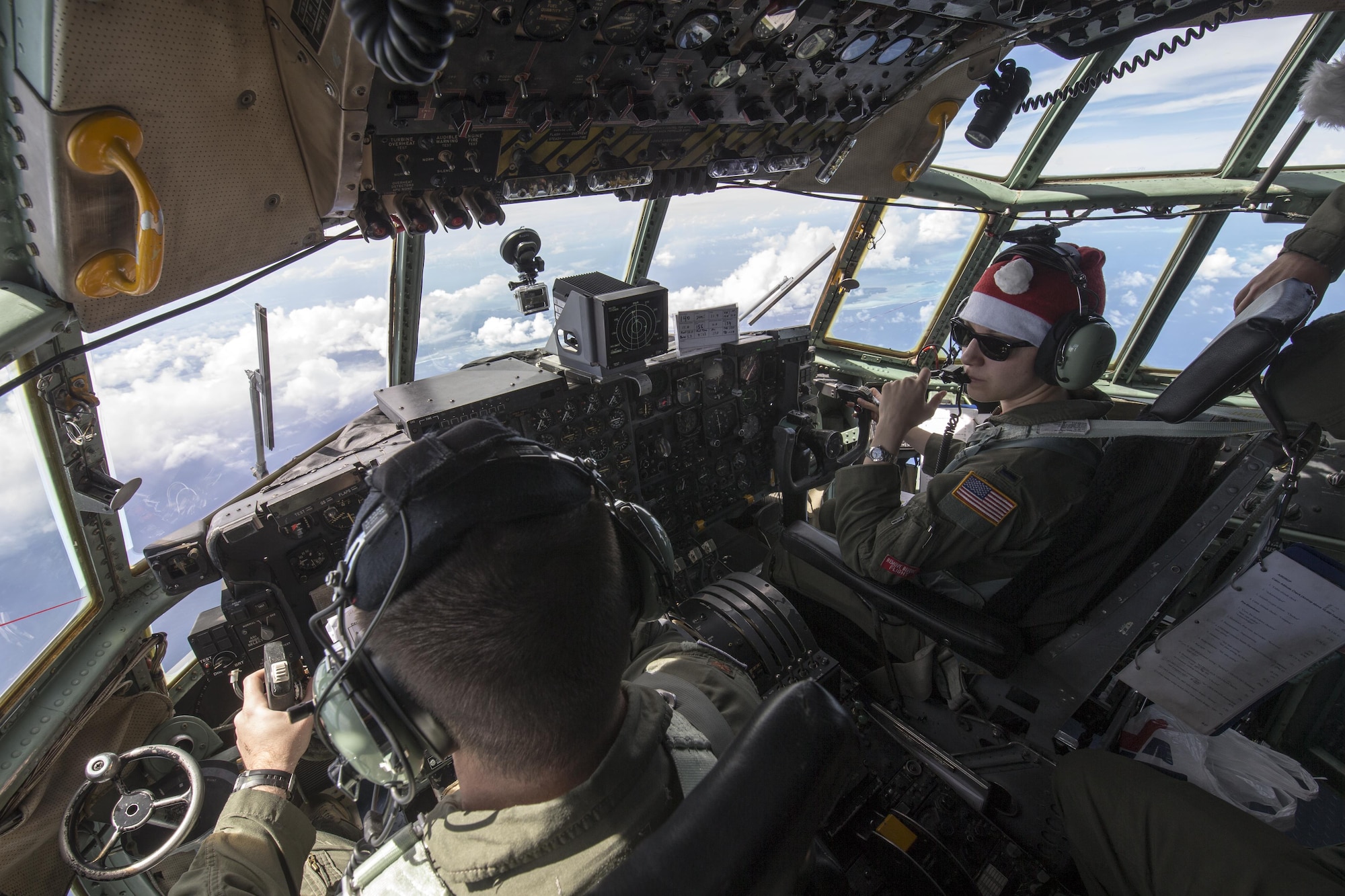 Maj. Lucas Crouch, 374th Airlift Wing, and 1st Lt. Sydney Croxton, 36th Airlift Squadron pilots, fly over Pacific Ocean Dec. 11, 2015, during Operation Christmas Drop. Every December, C-130H Hercules aircrews from Yokota head to Andersen Air Force Base to execute low-cost, low-altitude humanitarian airdrops to islanders throughout the Commonwealth of the Northern Marianas, Federated States of Micronesia, Republic of Palau. These islands are some of the most remote locations on the globe spanning a distance nearly as broad as the continental U.S. (U.S. Air Force photo by Osakabe Yasuo/Released)