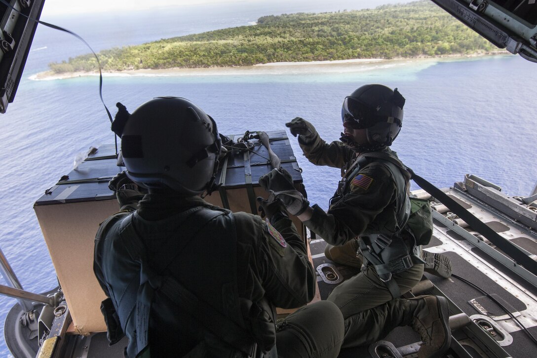Loadmasters with the 374th Operations Group check a low-cost, low-altitude bundle over Angaur, Republic of Palau, Dec. 11, 2015, during Operation Christmas Drop. This year marks the 64th year of Operation Christmas Drop and the first time international partners joined in execution through Japan Air Self-Defense Force and Royal Australian Air Force C-130 support. The event provides critical supplies to 56 Micronesian islands impacting about 20,000 people covering 1,000 by 1,800 nautical miles of operation area. (U.S. Air Force photo by Osakabe Yasuo/Released)