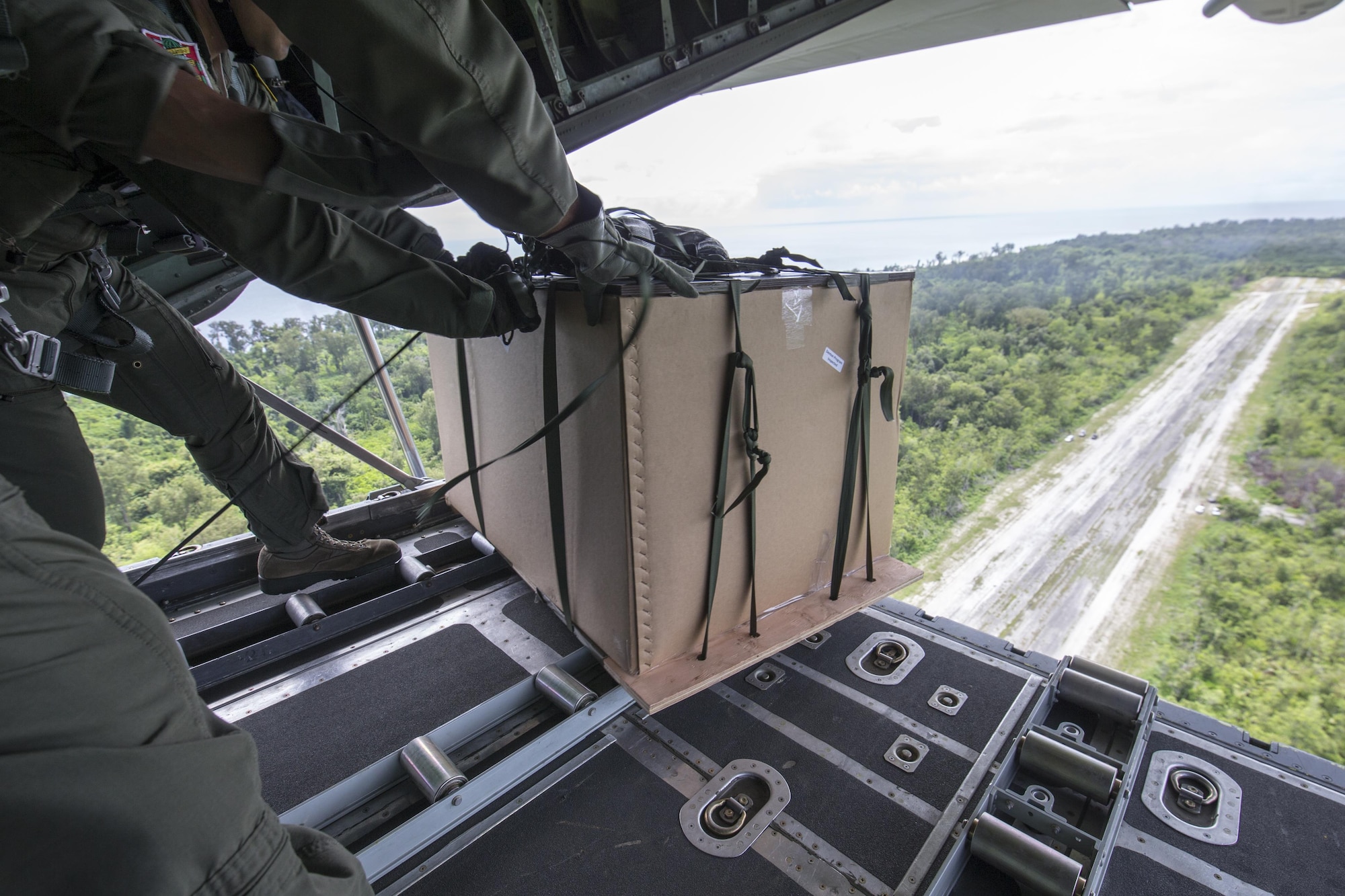 The 374th Operations Group loadmasters drop a low-cost, low-altitude bundle to Angaur airstrip, Republic of Palau, Dec. 11, 2015, during Operation Christmas Drop. This year marks the 64th year of Operation Christmas Drop and the first time international partners joined in execution through Japan Air Self-Defense Force and Royal Australian Air Force C-130 support. The event provides critical supplies to 56 Micronesian islands impacting about 20,000 people covering 1,000 by 1,800 nautical miles of operation area. (U.S. Air Force photo by Osakabe Yasuo/Released)