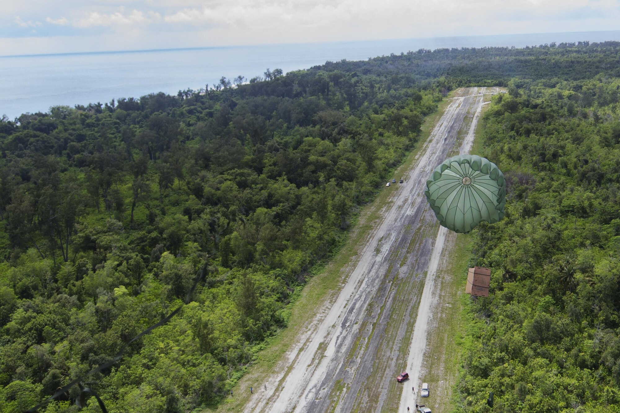 A low-cost, low-altitude bundle of donated goods drops to Angaur island, Republic of Palau, Dec. 11, 2015, during Operation Christmas Drop. This year marks the 64th year of Operation Christmas Drop and the first time international partners joined in execution through Japan Air Self-Defense Force and Royal Australian Air Force C-130 support. The event provides critical supplies to 56 Micronesian islands impacting about 20,000 people covering 1,000 by 1,800 nautical miles of operation area. (U.S. Air Force photo by Osakabe Yasuo/Released)
