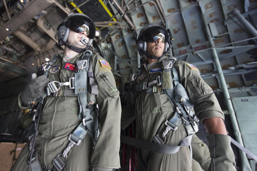 (Left to right) Staff Sgt. Joel Powell, 374th Operations Support Squadron, and Chief Master Sgt. Troy Coville, Pacific Air Forces, watch a low-cost, low-altitude bundle as it drops to Angaur island, Republic of Palau, Dec. 11, 2015, during Operation Christmas Drop. This is a PACAF event which includes a partnership between the 374th Airlift Wing, Yokota Air Base, Japan; the 36th Wing, Andersen Air Force Base, Guam; the 734th Air Mobility Squadron, Andersen AFB of the 515th Air Mobility Operations Wing, Joint Base Pearl Harbor-Hickam. Hawaii; the University of Guam; and the Operation Christmas Drop private organization. It is the longest-running Department of Defense humanitarian airdrop operation with 2015 being the first trilateral execution with support from Japan Air Self-Defense Force and Royal Australian Air Force. (U.S. Air  Force photo by Osakabe Yasuo/Released)